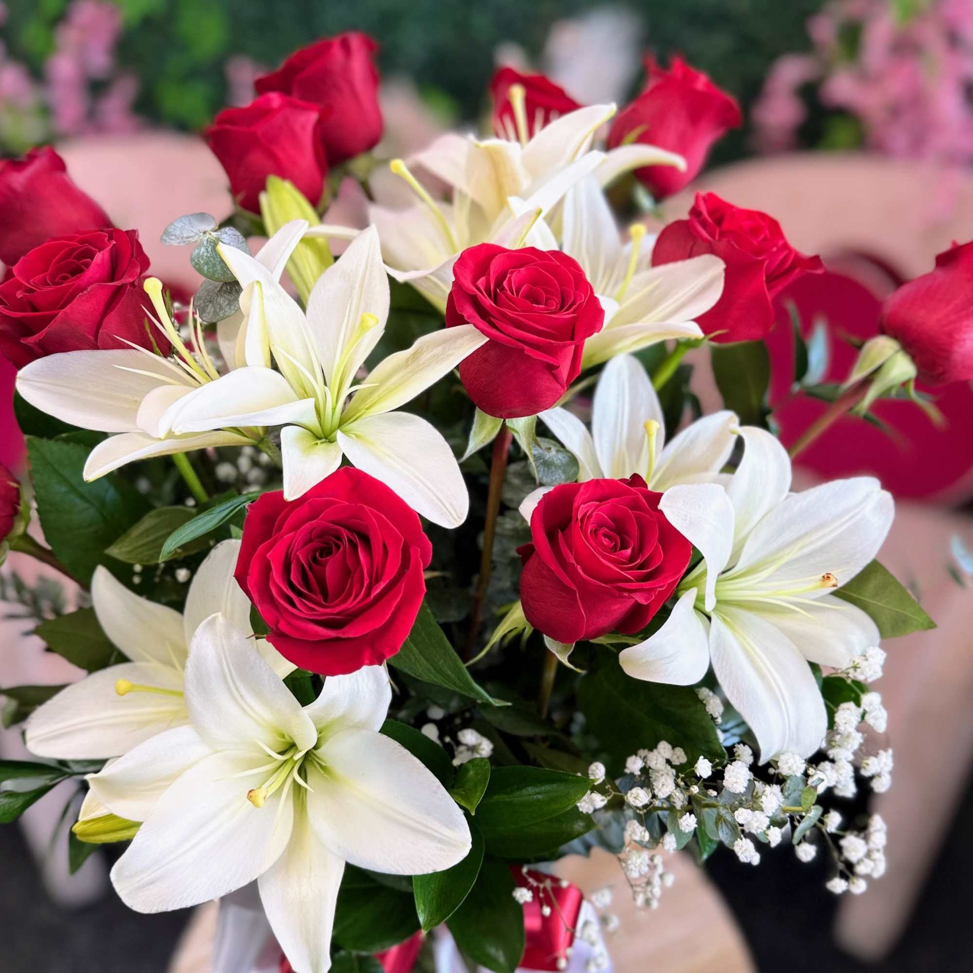 Beautiful fresh red roses paired with elegant white lilies, arranged in a