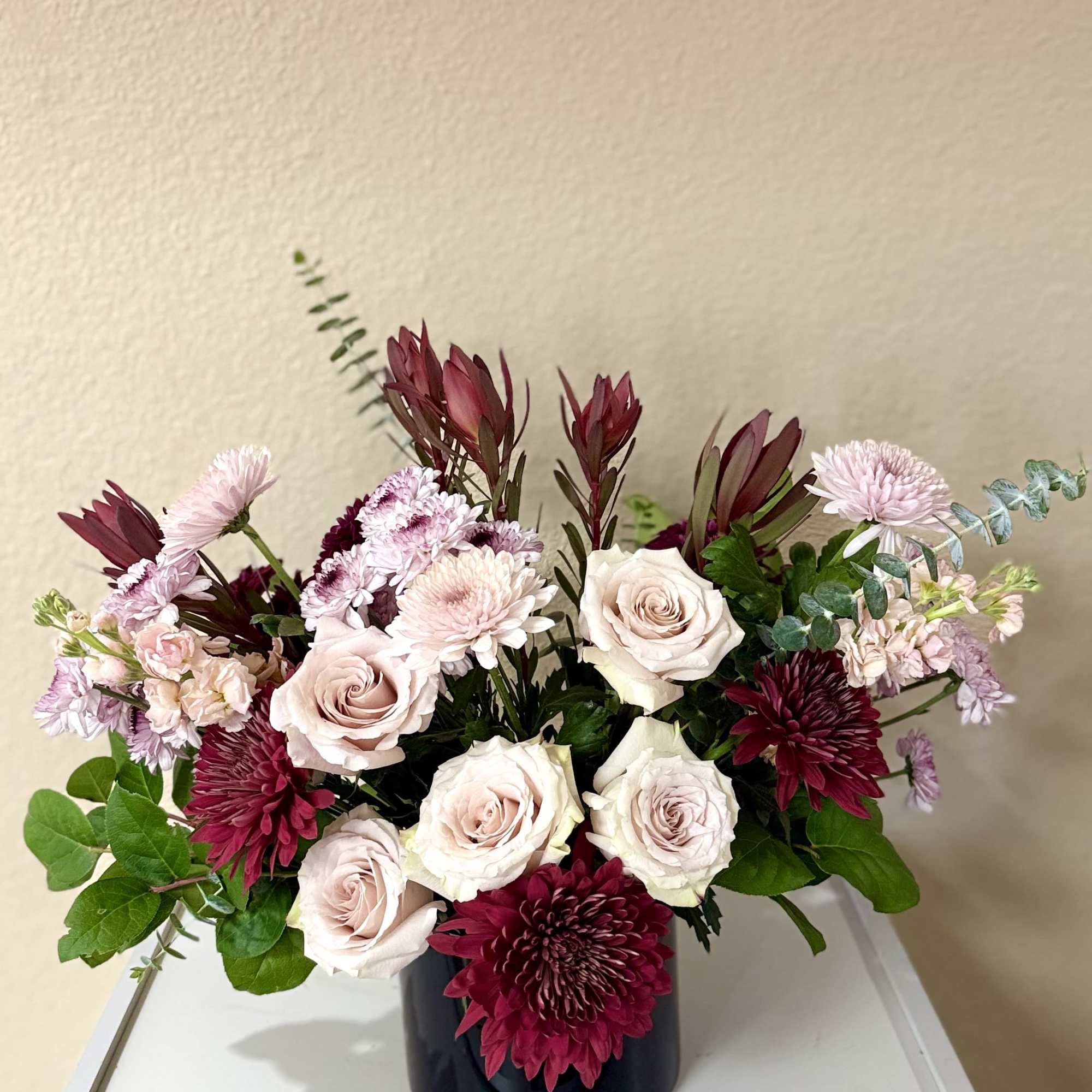 A sophisticated  blend of soft blush roses paired with deep merlot