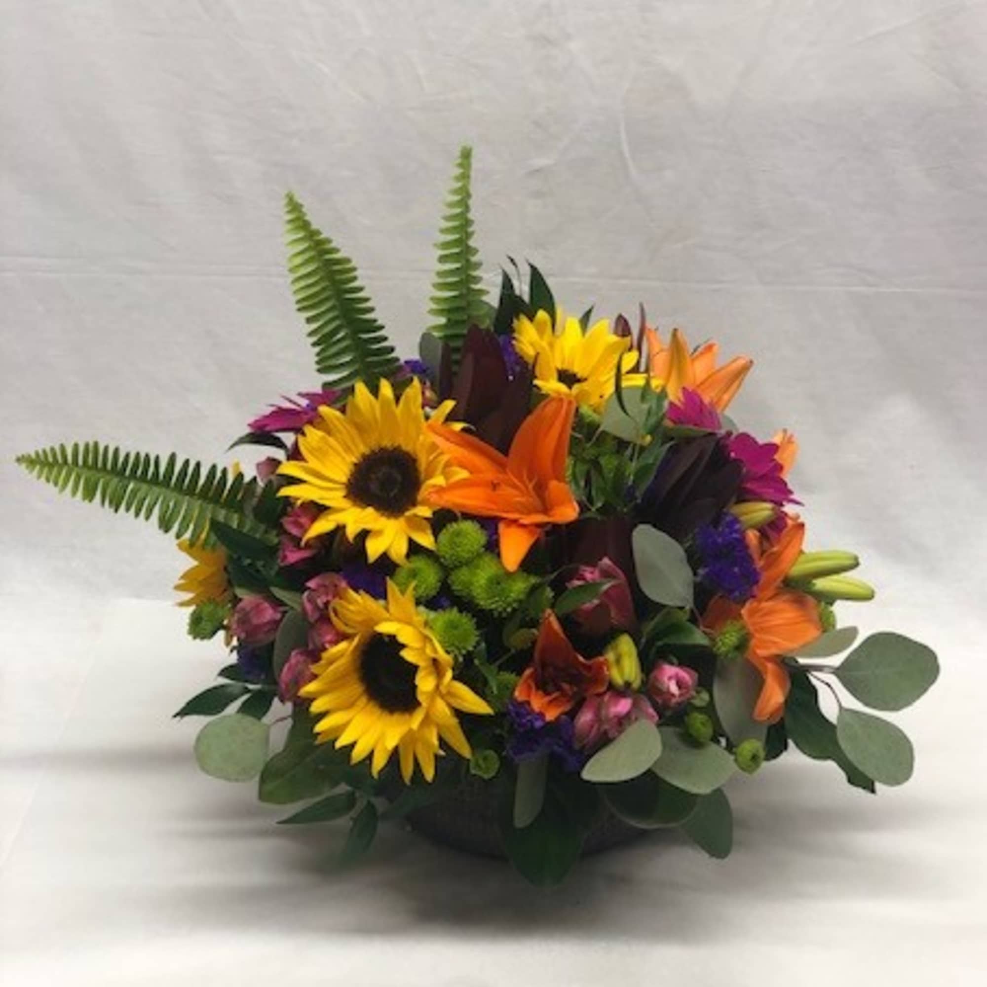 Such charming assortment of sunny sunflowers, unique orange roses, bold hot pink