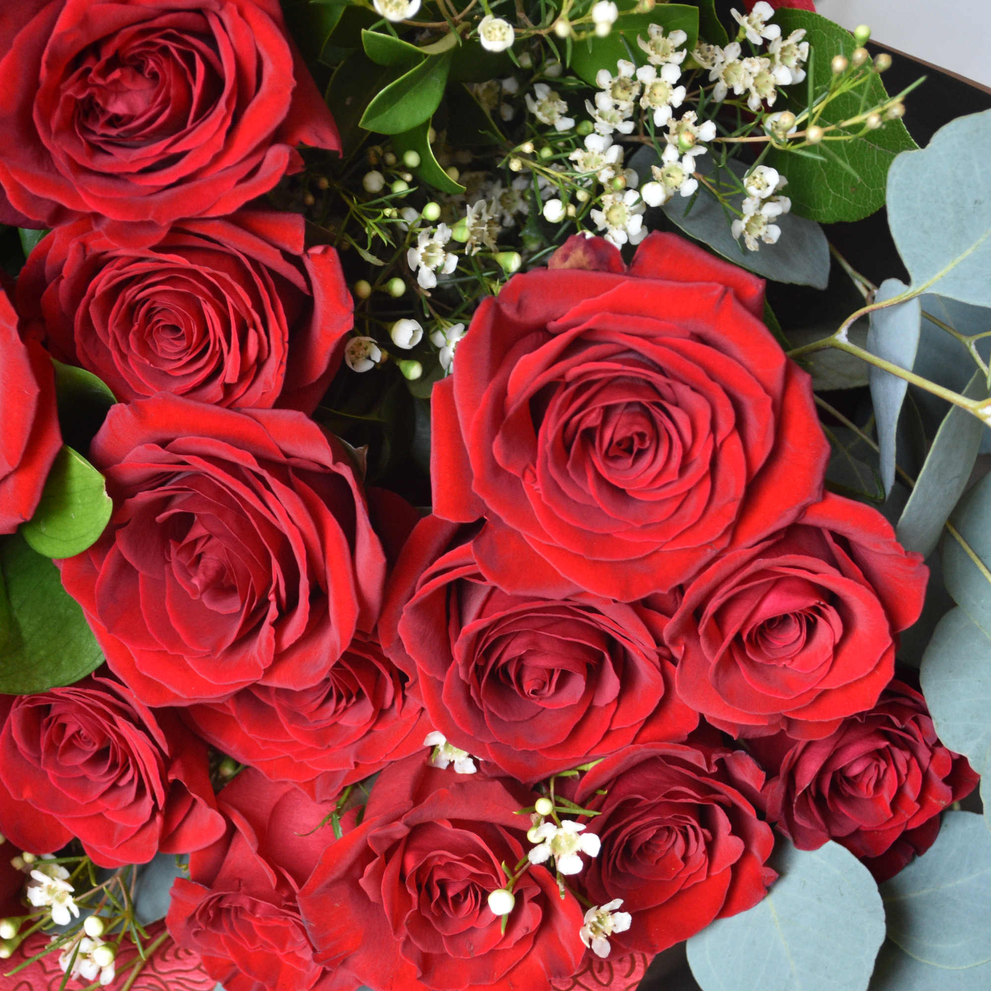 Featuring luxurious roses arranged in lush greenery, wrapped in premium paper and