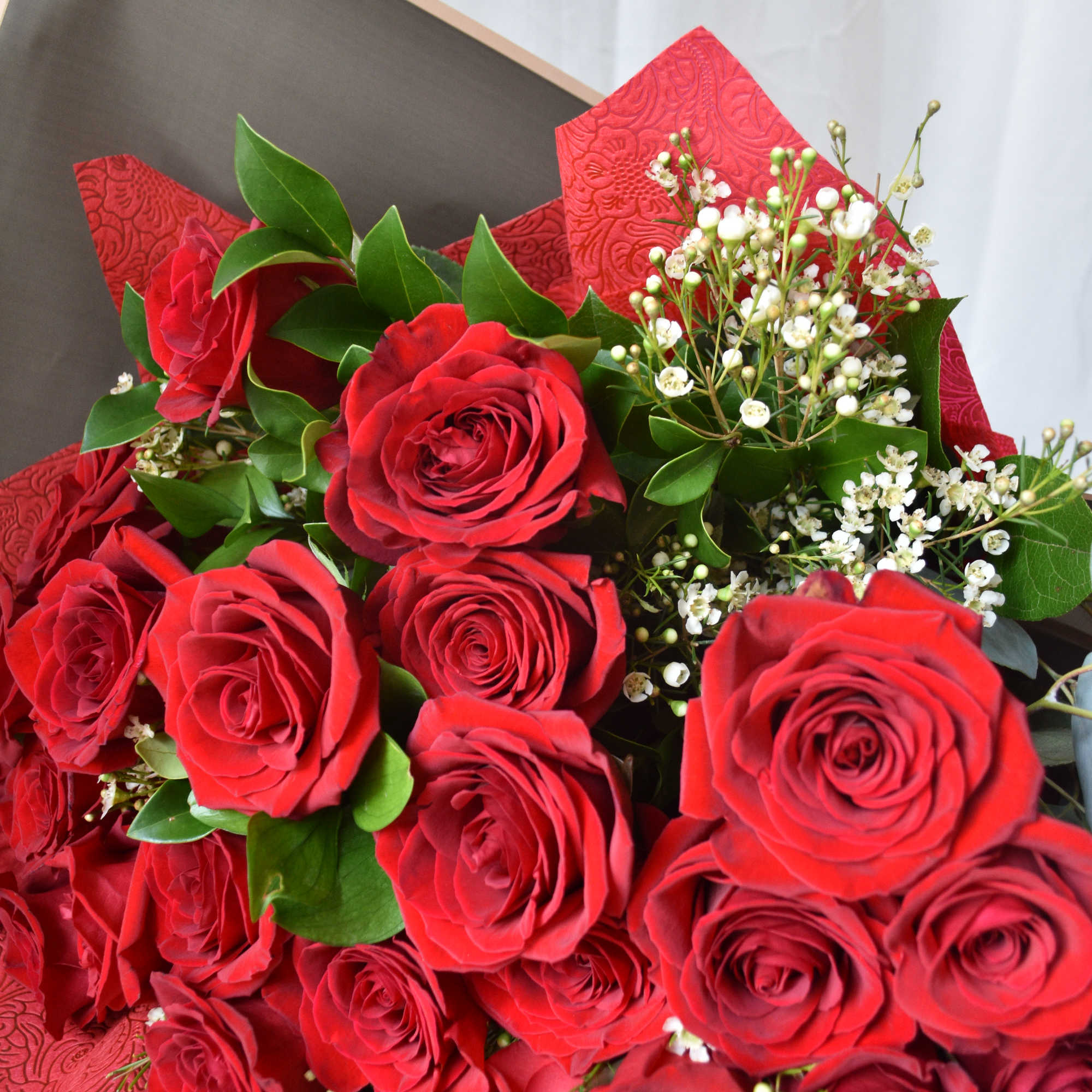 Featuring luxurious roses arranged in lush greenery, wrapped in premium paper and