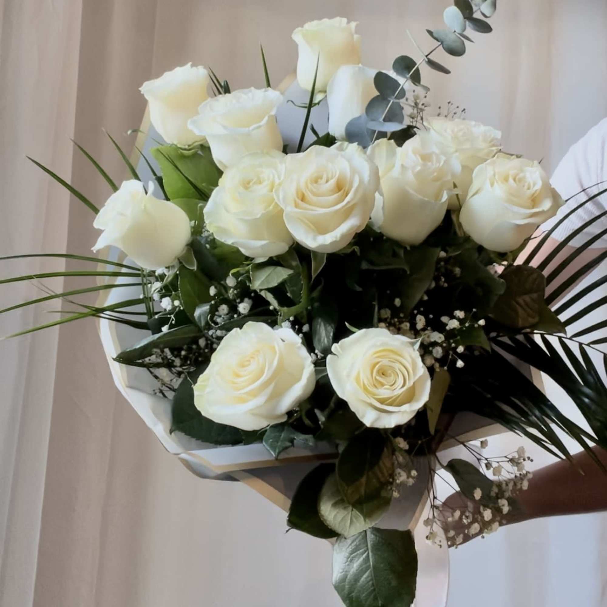 Featuring luxurious roses arranged in lush greenery, wrapped in premium paper and
