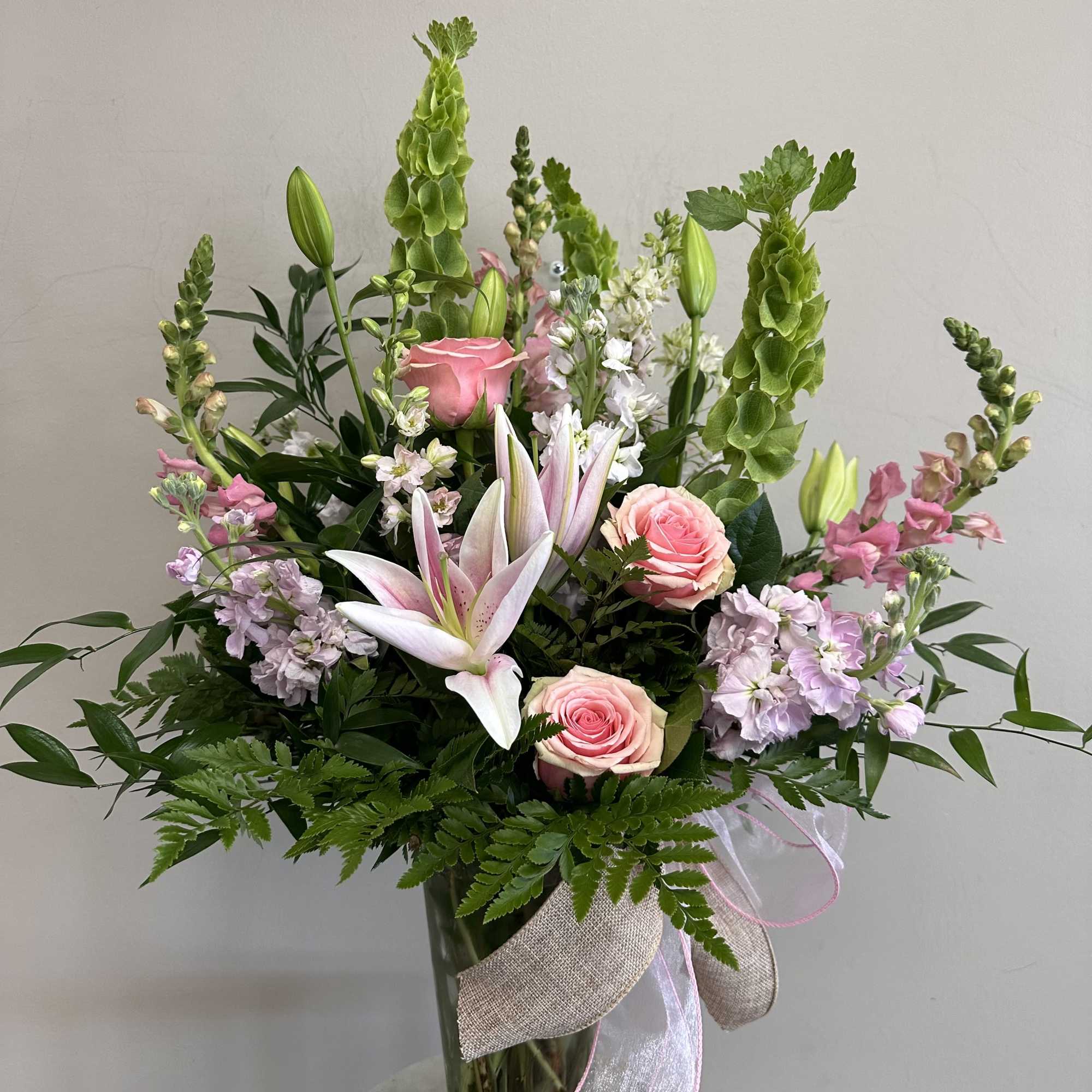 Soft pink larkspur, snap dragons, roses, lilies, stock and lisianthus meet in