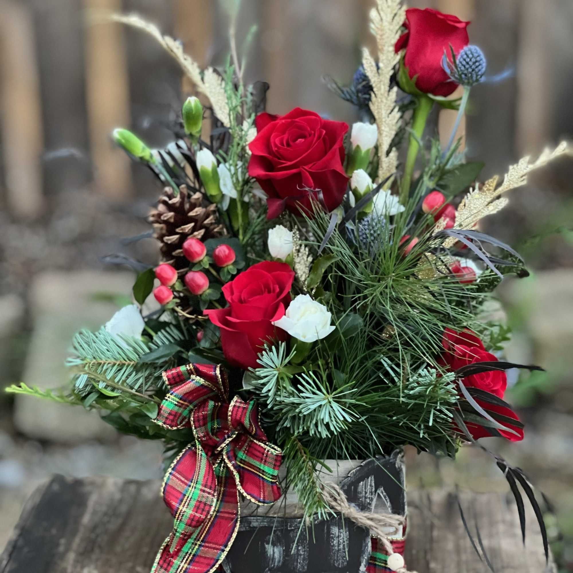 A beautiful flower arrangement nestled in a wooden box and includes a