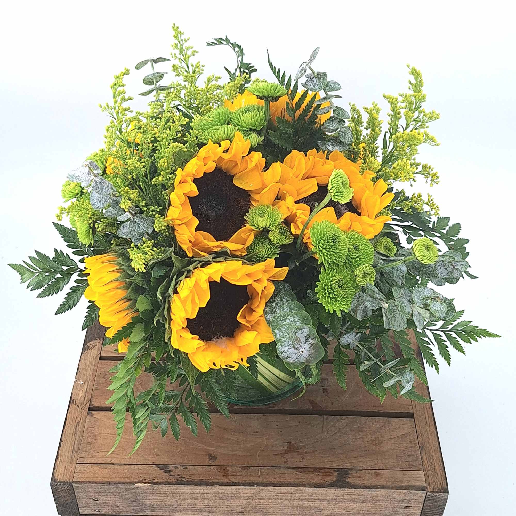 Introducing our cheerful and vibrant flower arrangement featuring sunflowers in a leaf-lined