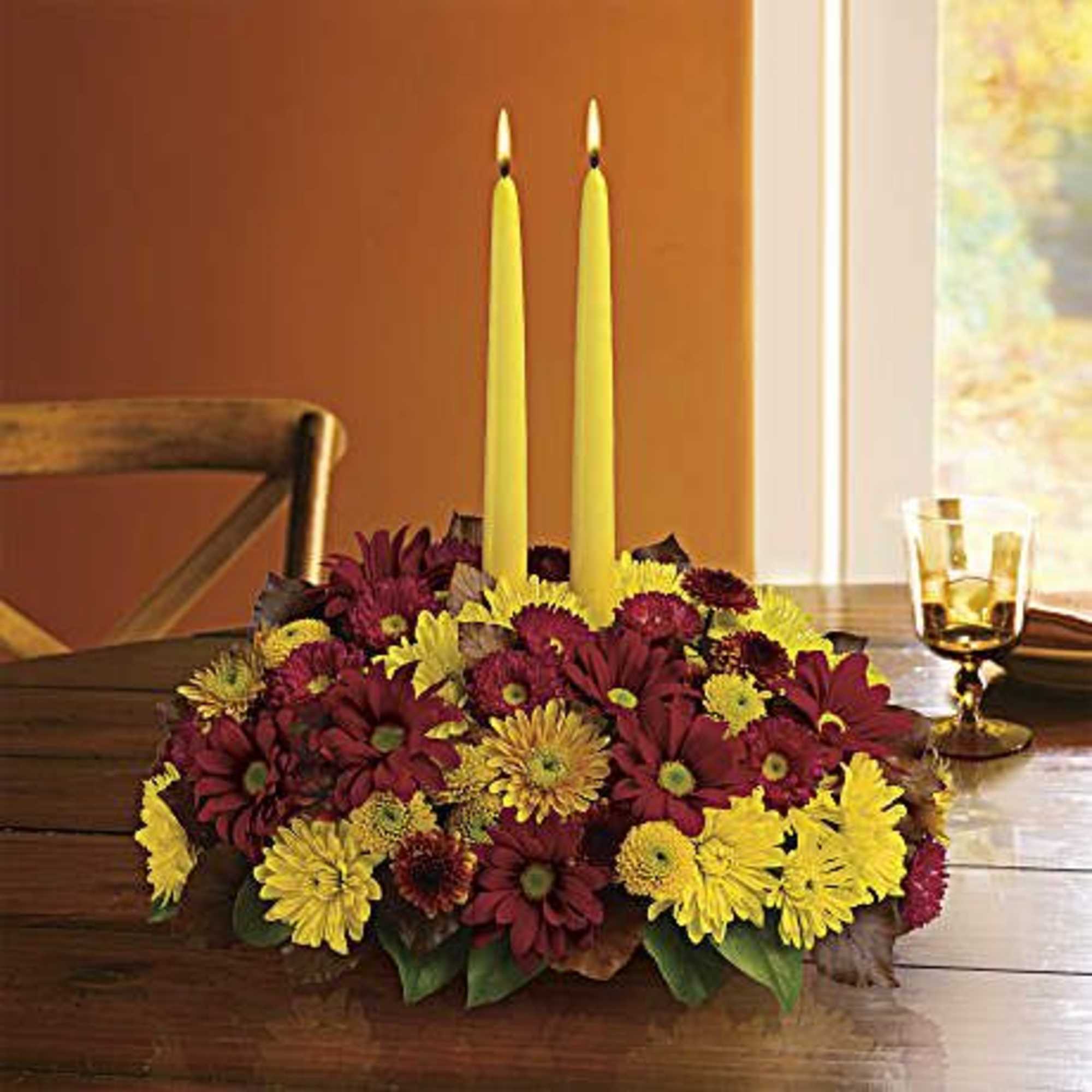 Happy yellow mums and a golden taper candle bring sunshine to your