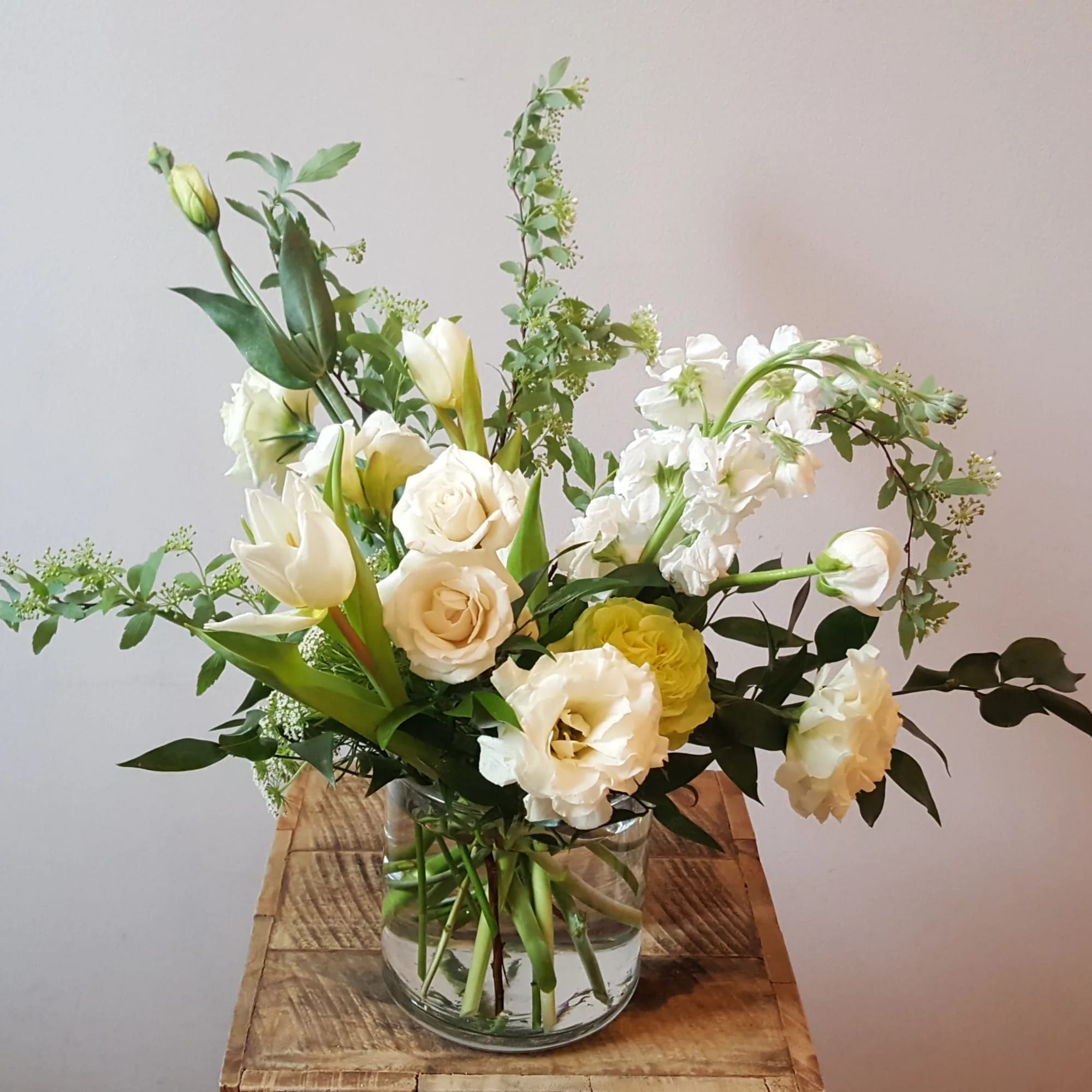 Elegant, soft, and full arrangement featuring larkspur, freesia, lisianthus, and other seasonal