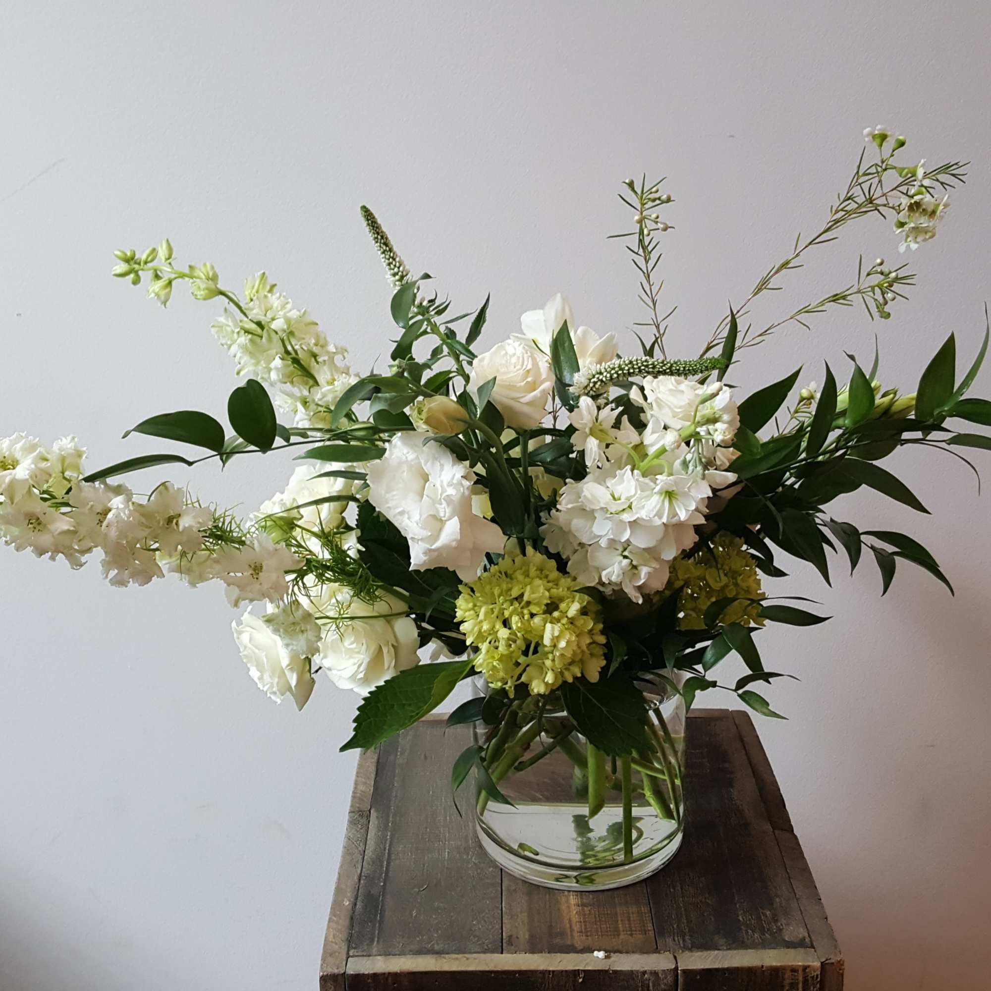 Elegant, soft, and full arrangement featuring larkspur, freesia, lisianthus, and other seasonal