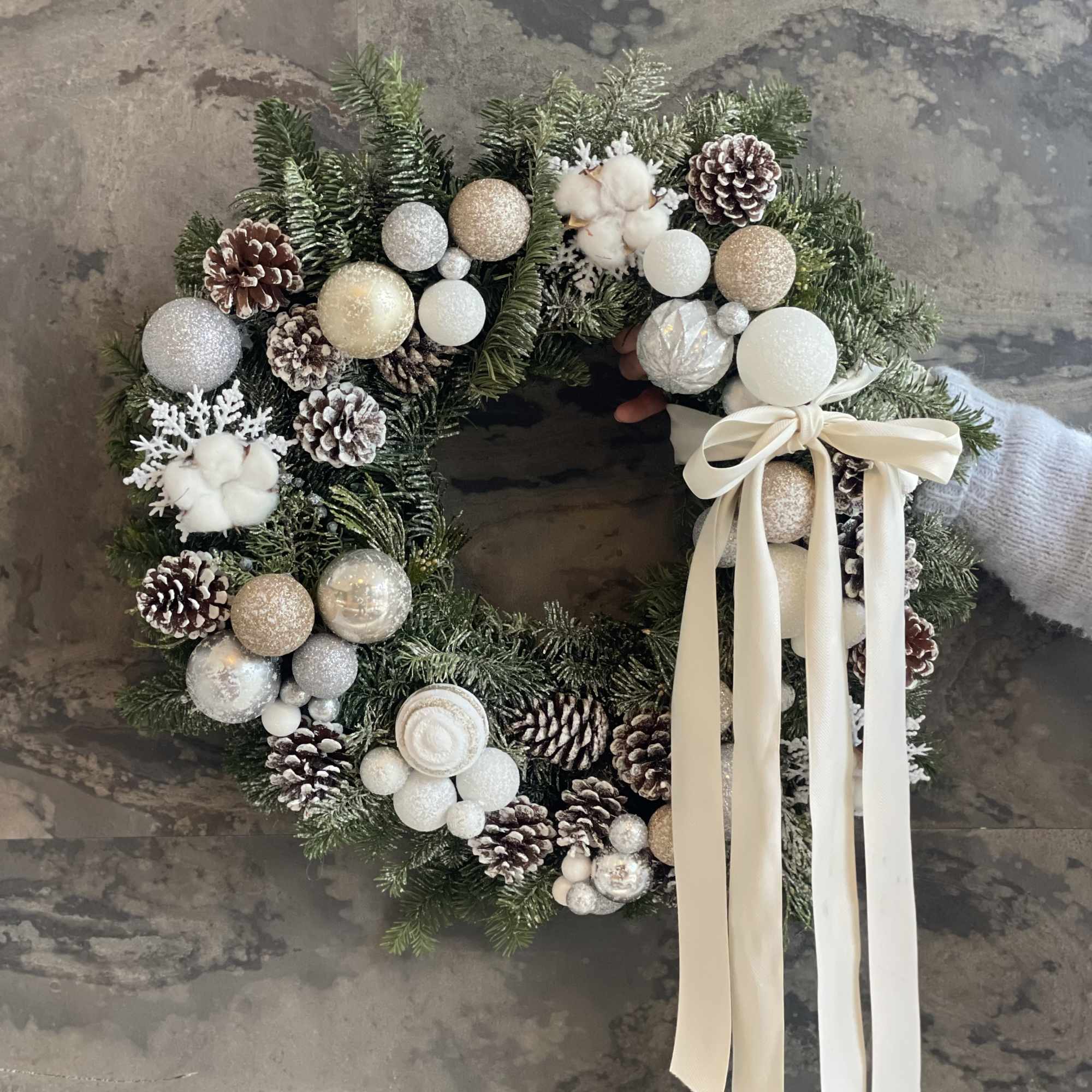 This luxurious winter wreath is crafted from fresh evergreens and adorned with