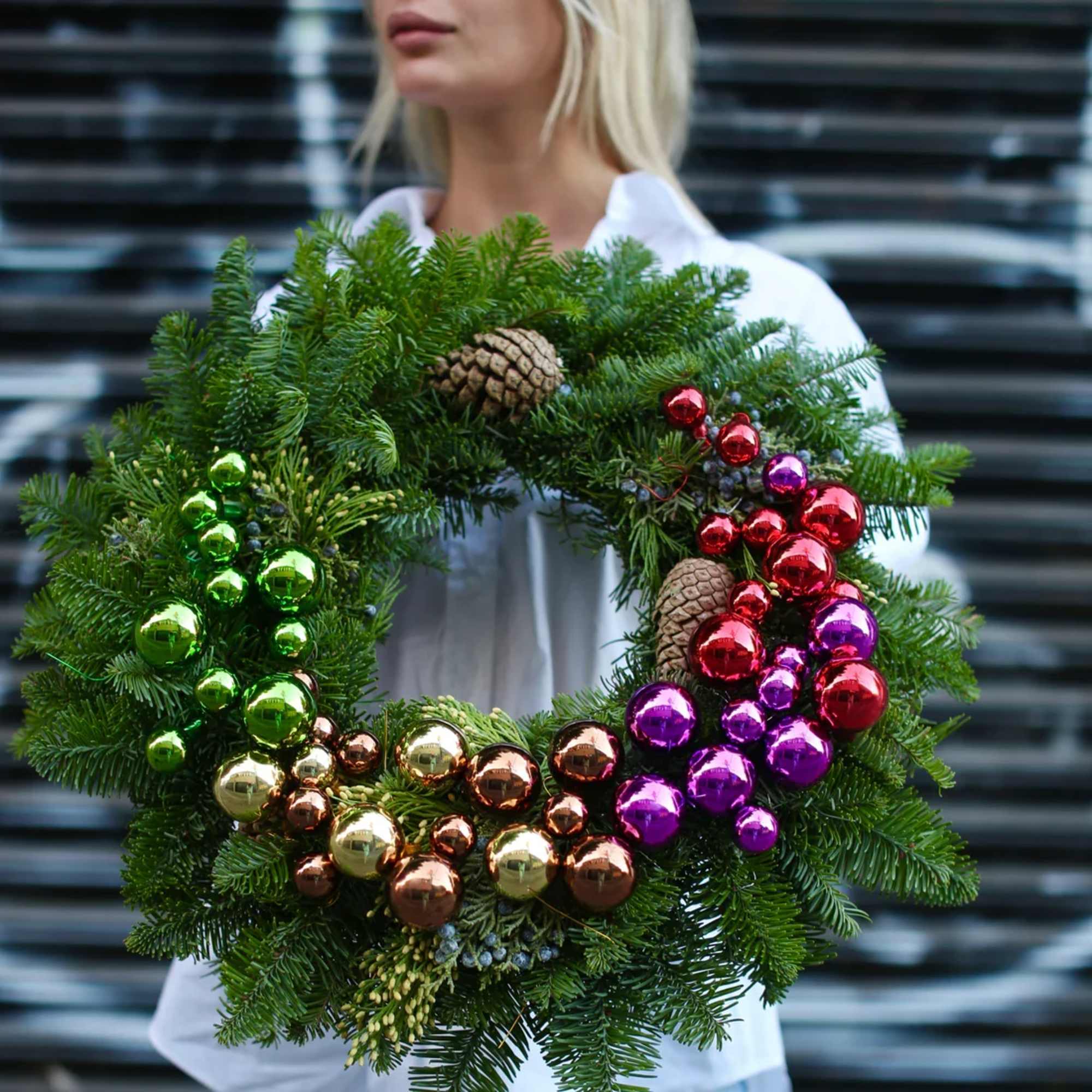 This stunning holiday wreath is crafted from fresh, fragrant evergreen branches and