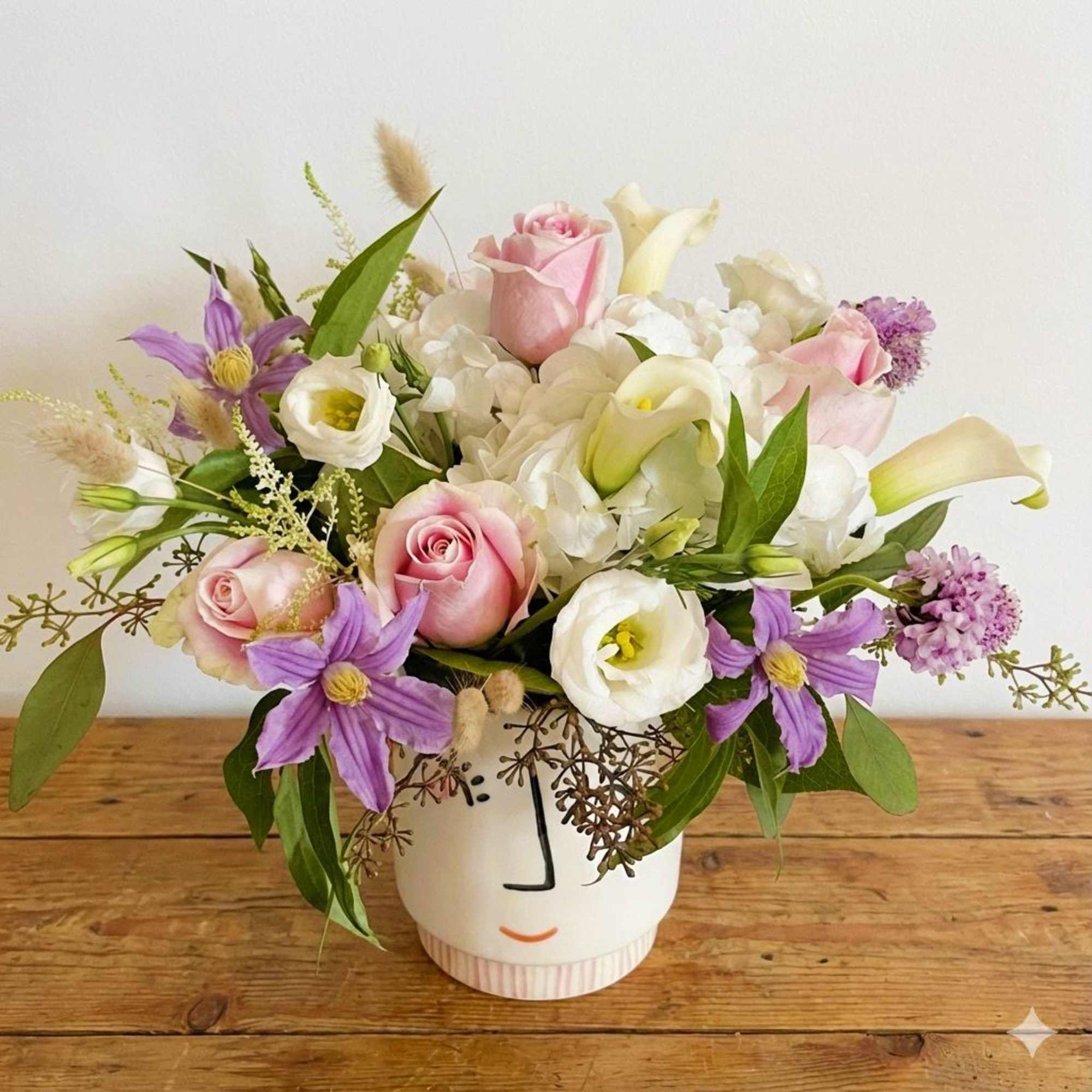 This arrangement is presented in a very unique smile ceramic vase. It