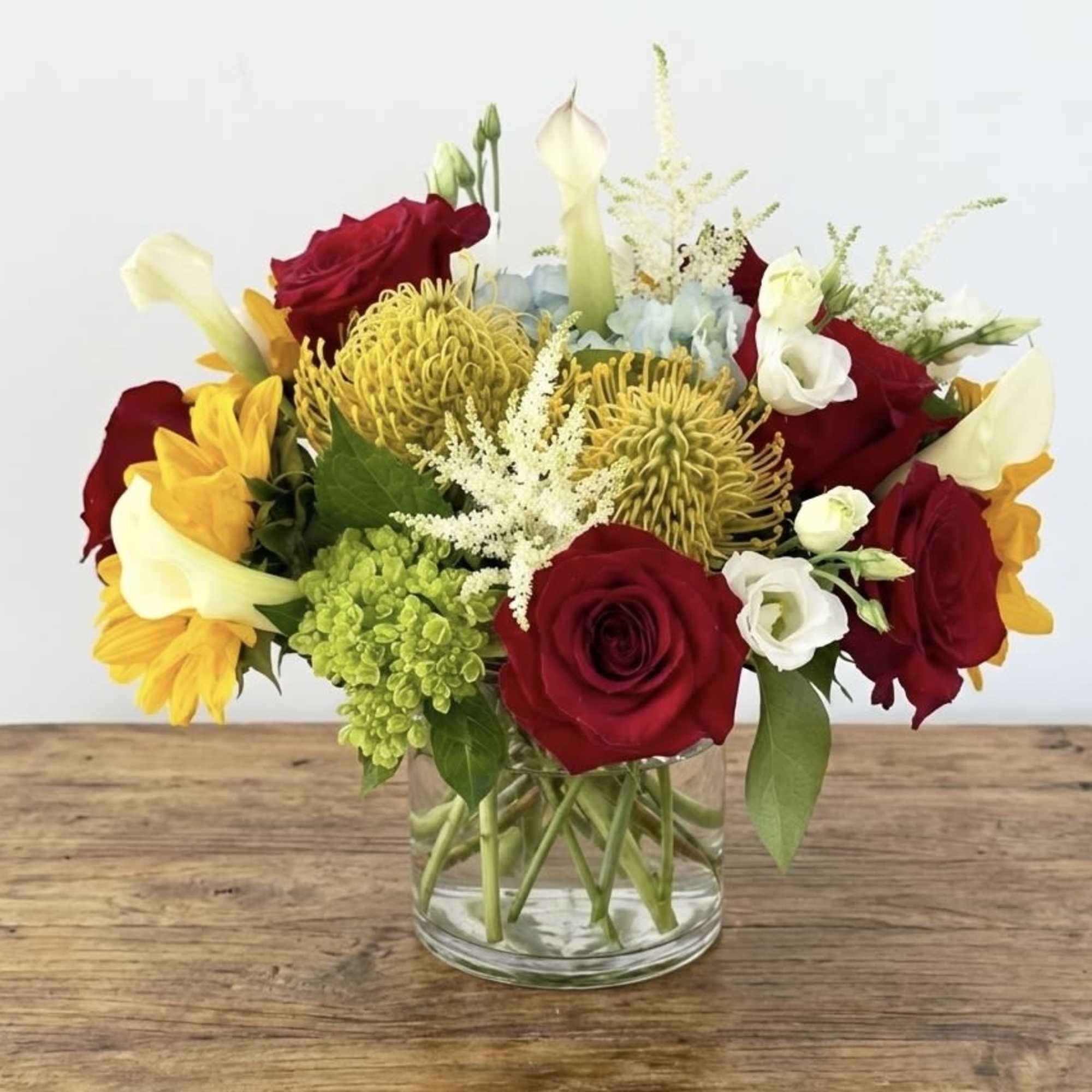 This arrangement is presented in a 5&quot; ceramic vase. It features sunflowers