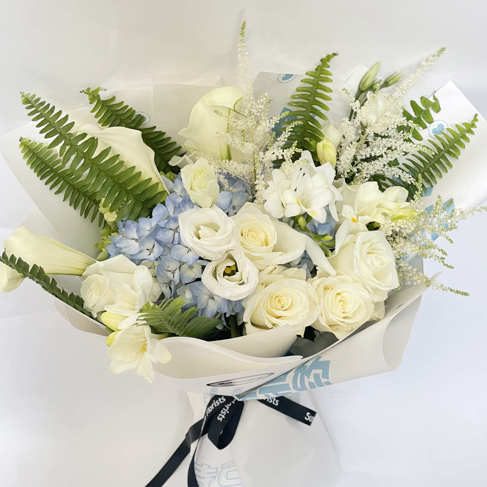 This bouquet features white and soft blue colors. 