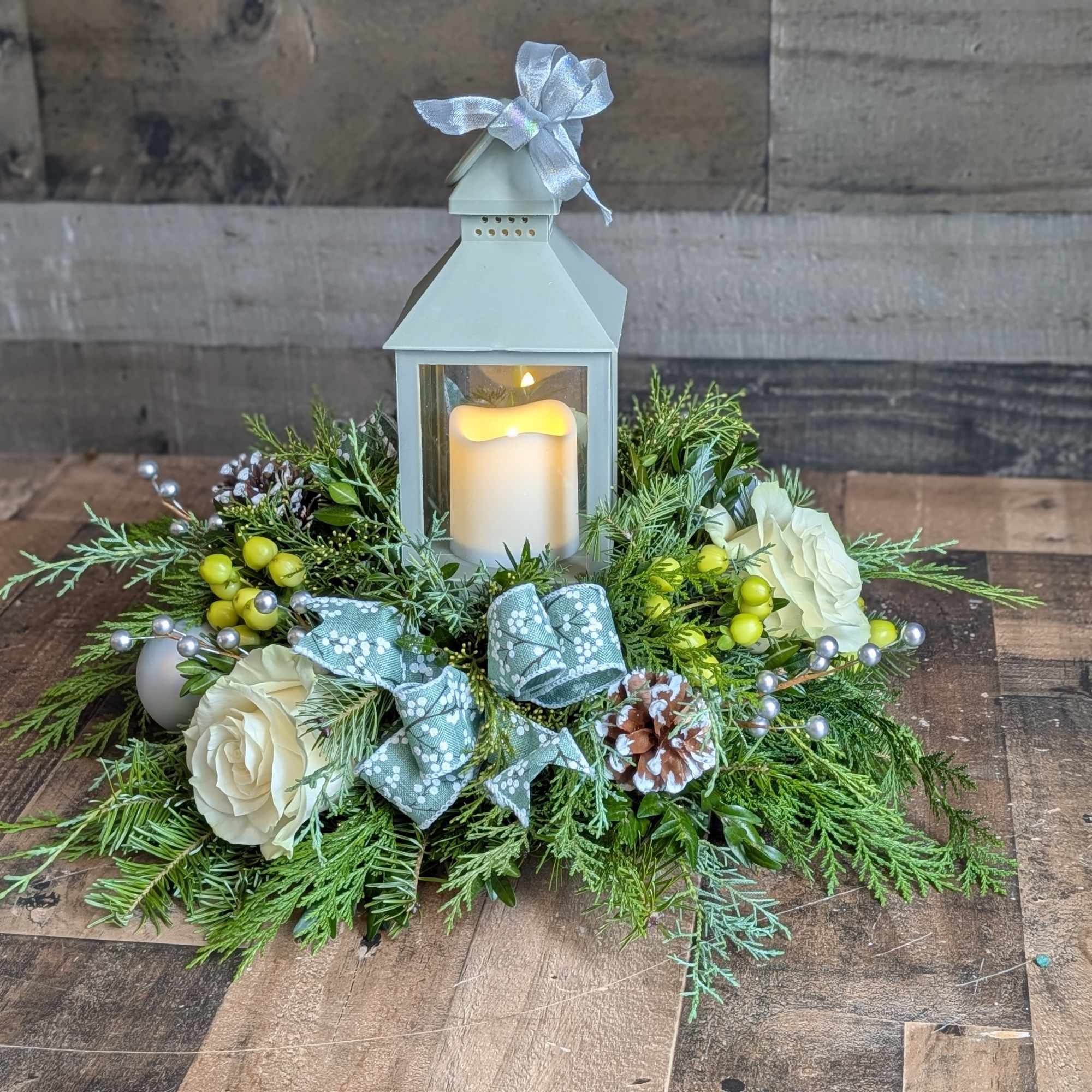 Shown as Standard
Sparkley evergreens, pinecones, silver ornaments, silver berries, bows, hypericum berries