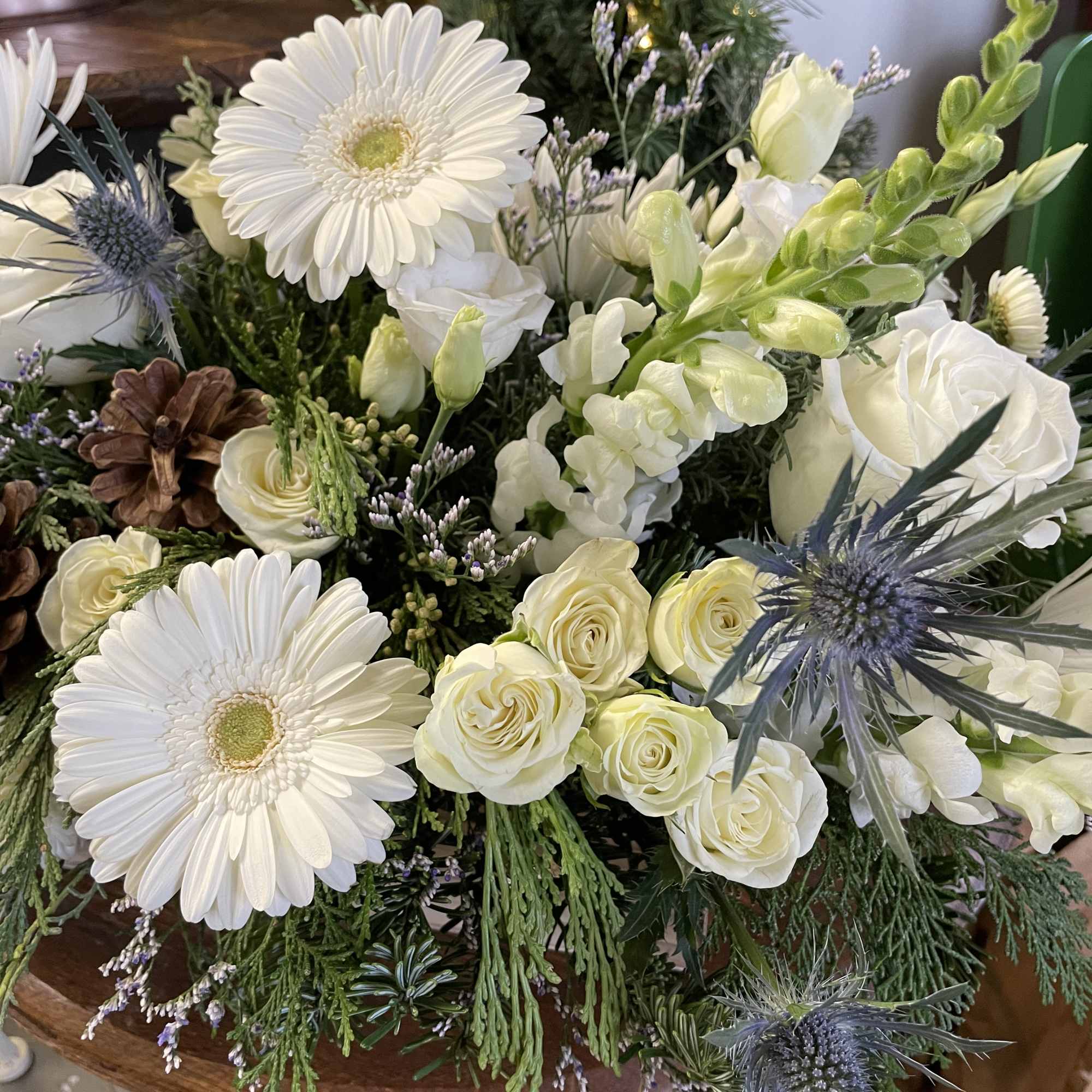 White washed wooden centerpiece filled with seasonal winter foliage and crisp white