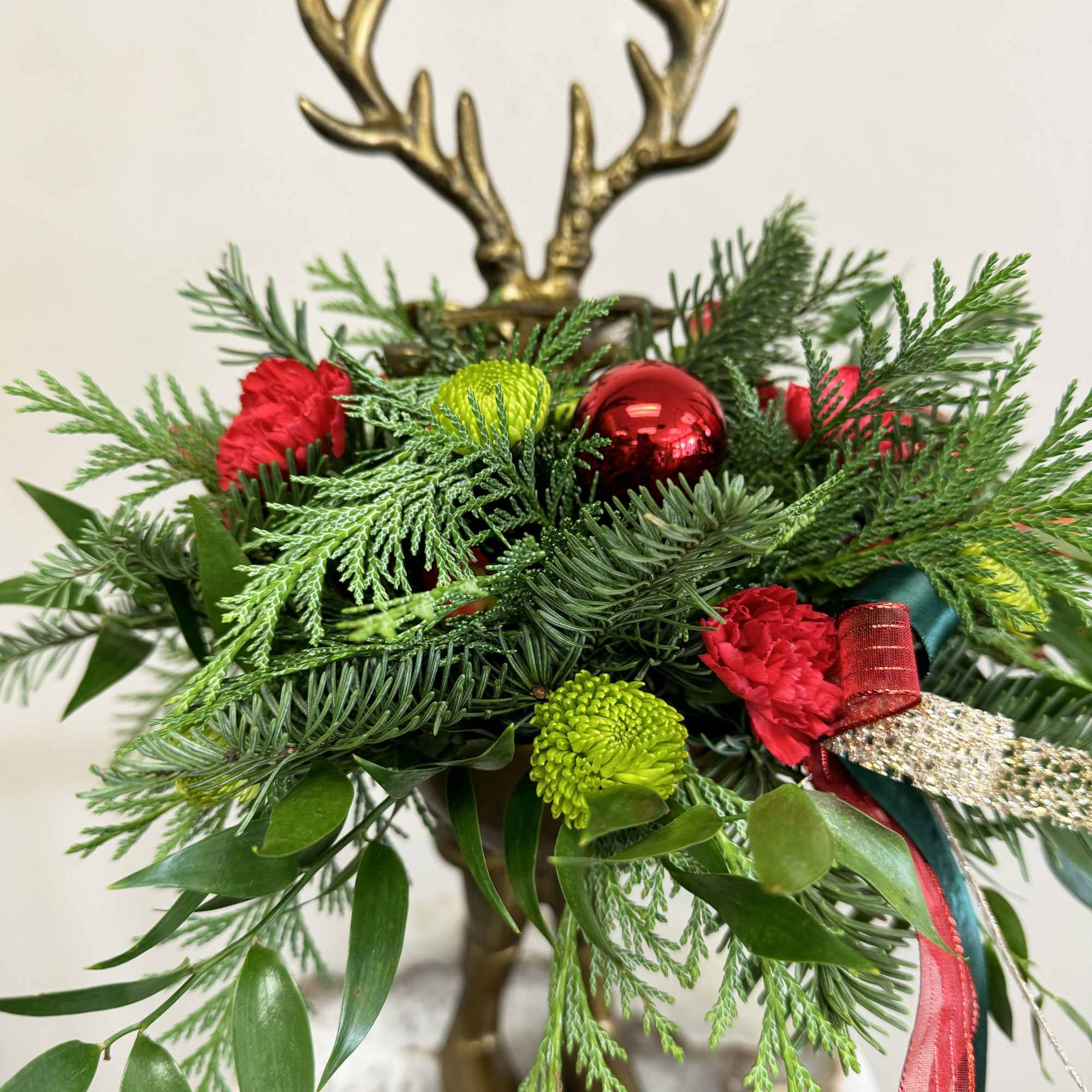 Showcased in a charming keepsake brass reindeer vase, this festive display features