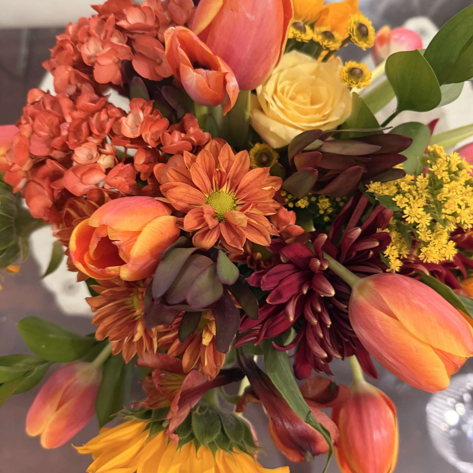 This is a vibrant fall-inspired arrangement that radiates warmth and coziness. The
