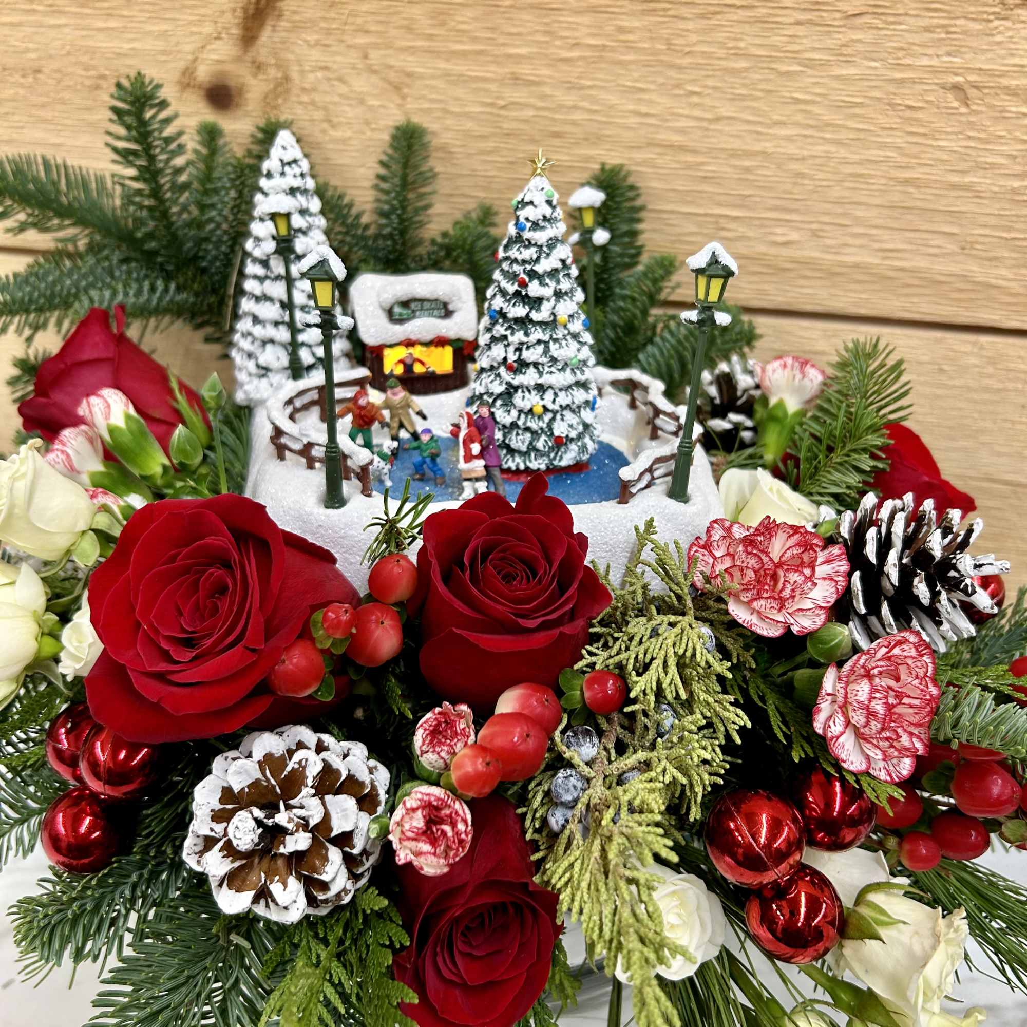 Red and  white flowers with a small light up house arrangement