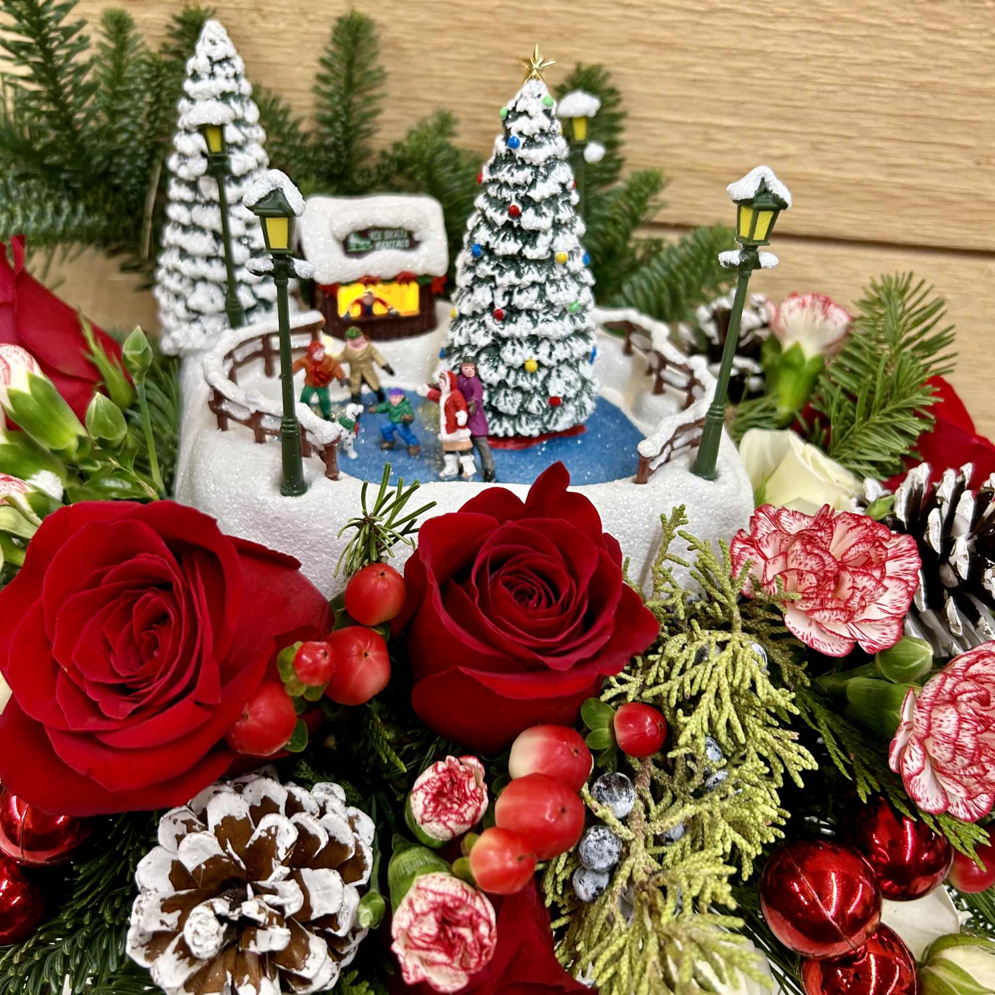 Red and  white flowers with a small light up house arrangement