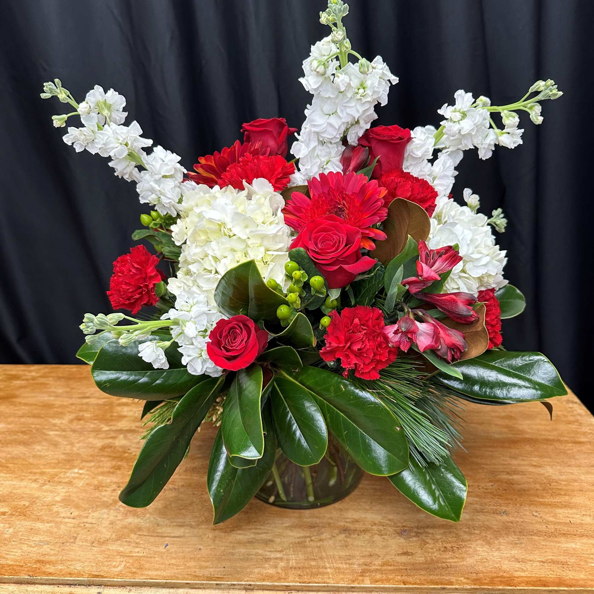 Celebrate the season with this stunning arrangement of vibrant red roses, carnations