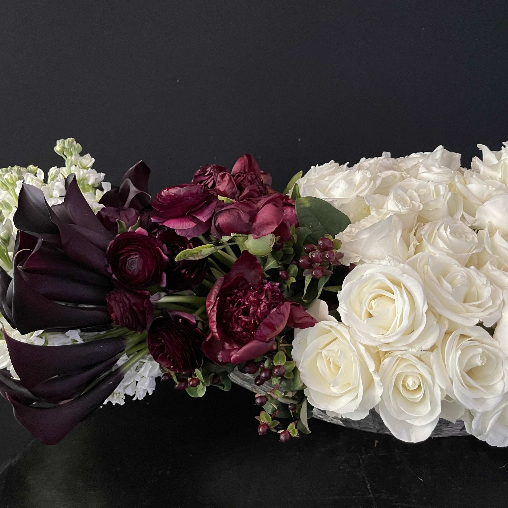 This design includes:
40 dark purple almost black callas
75 white roses
10 burgundy peonies