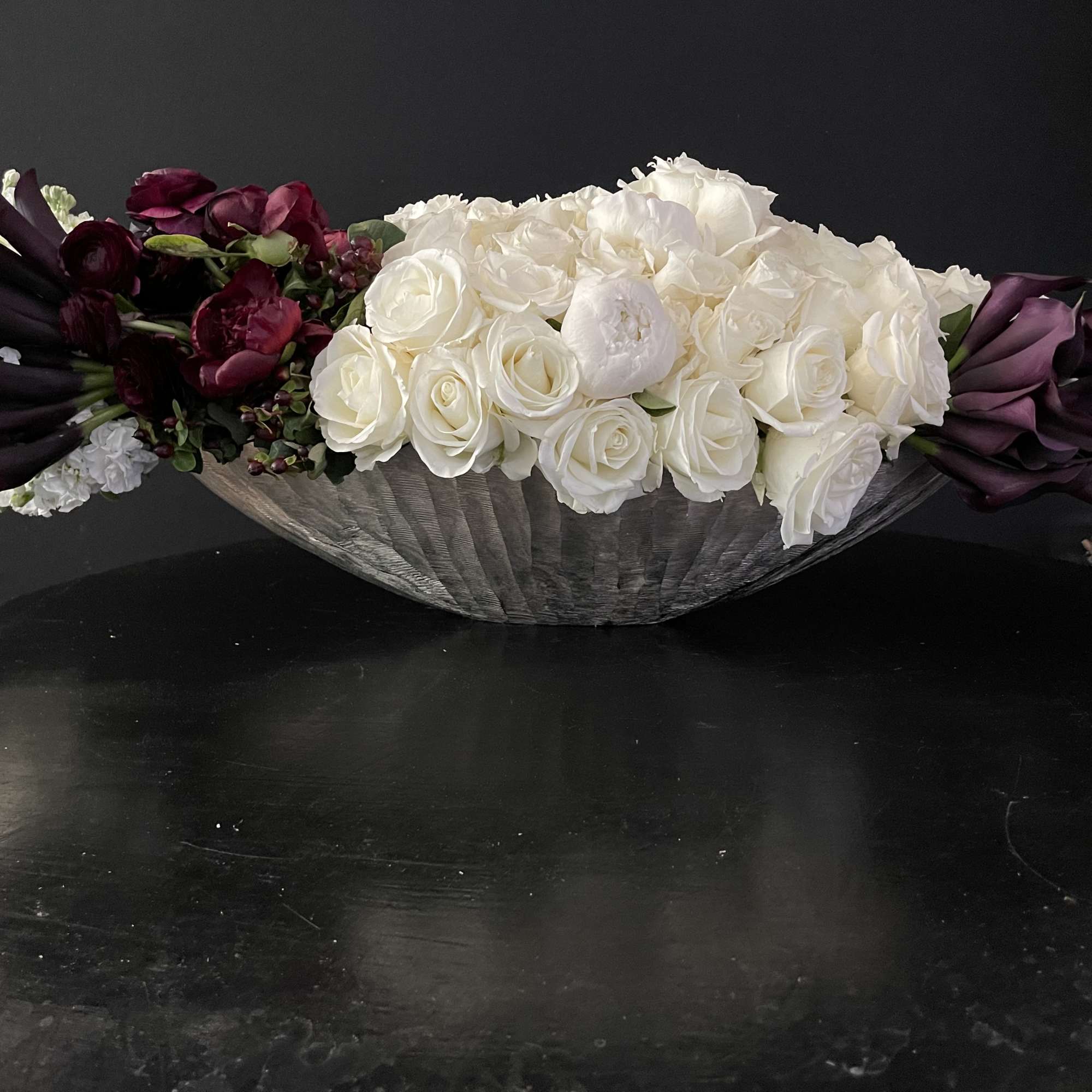 This design includes:
40 dark purple almost black callas
75 white roses
10 burgundy peonies