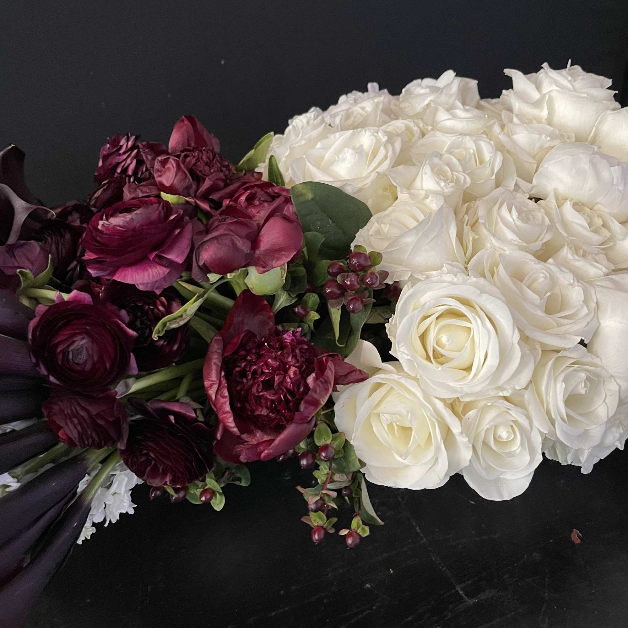 This design includes:
40 dark purple almost black callas
75 white roses
10 burgundy peonies