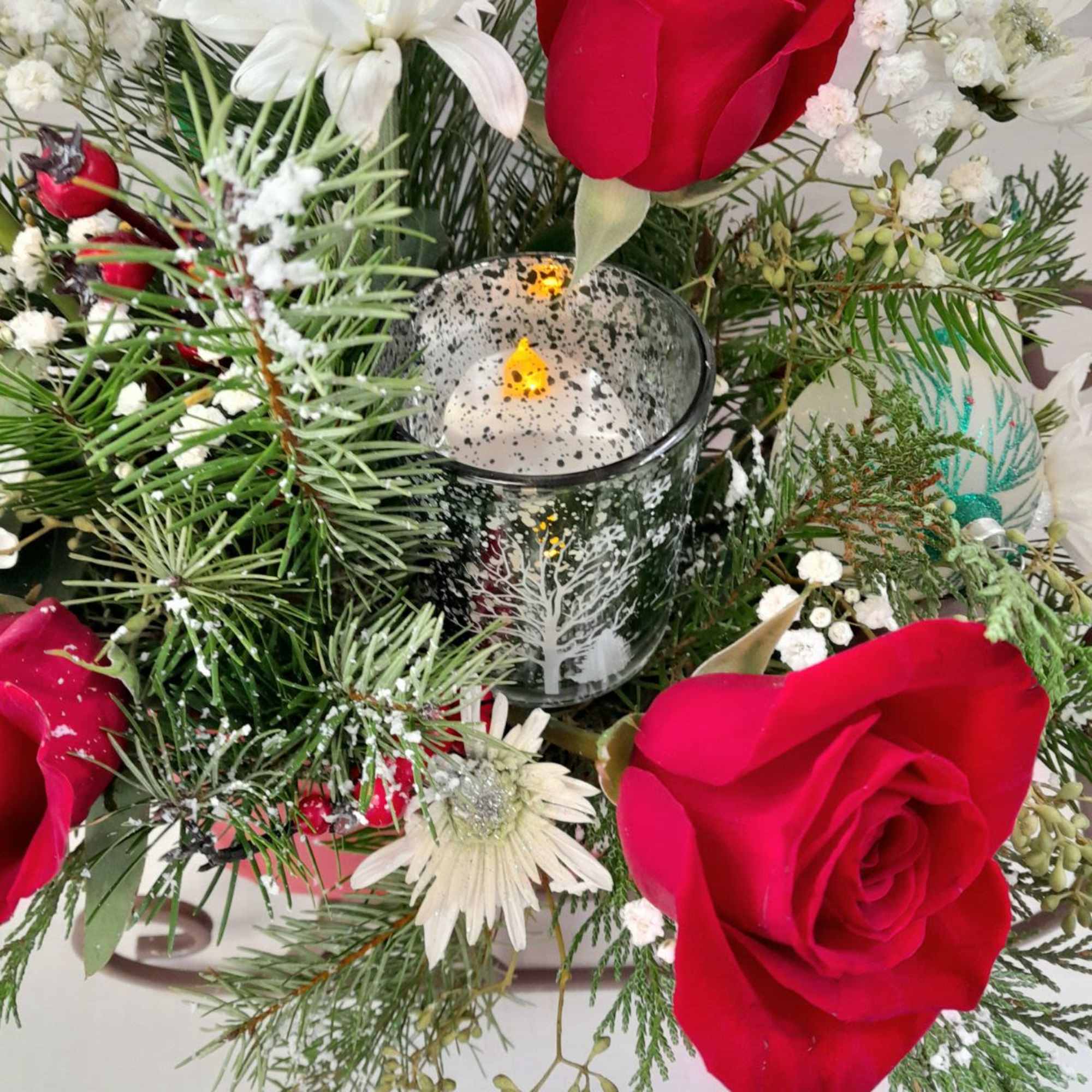 A large traditional sleigh filled with fresh red roses, holiday mums, snowy