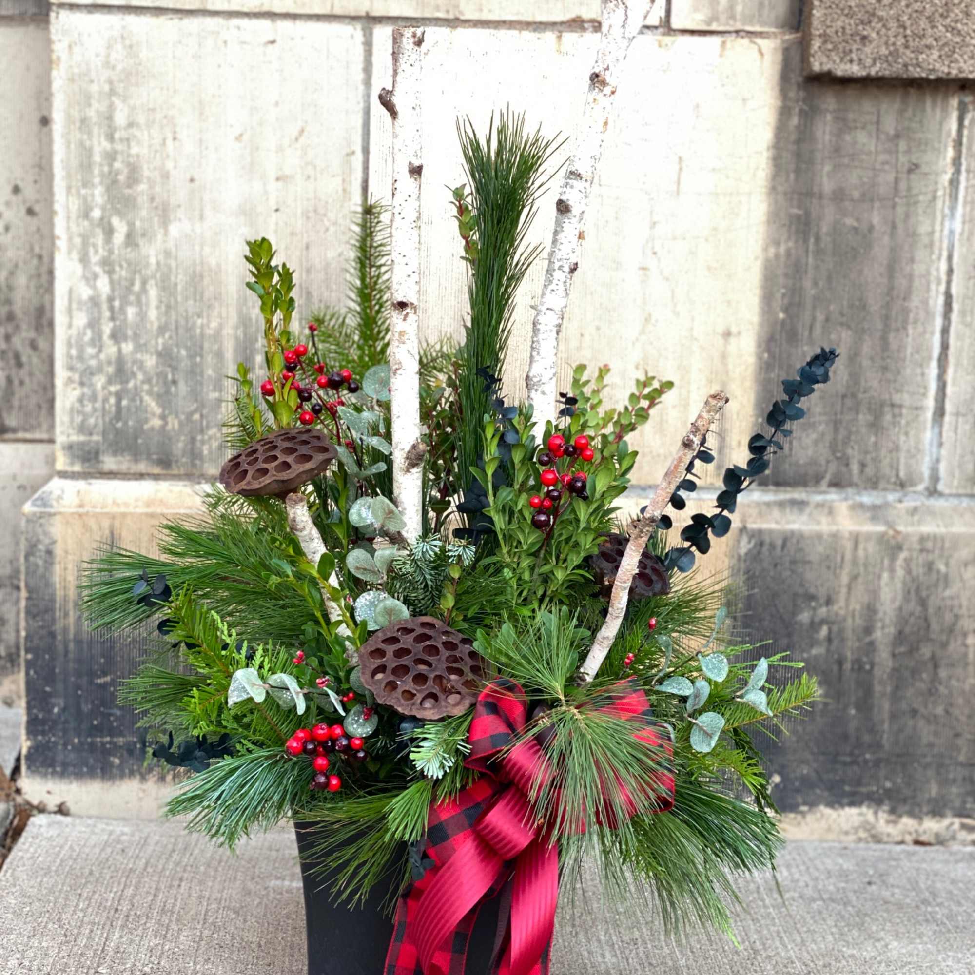 A charming evergreen porch pot with a cozy country-inspired theme, featuring a