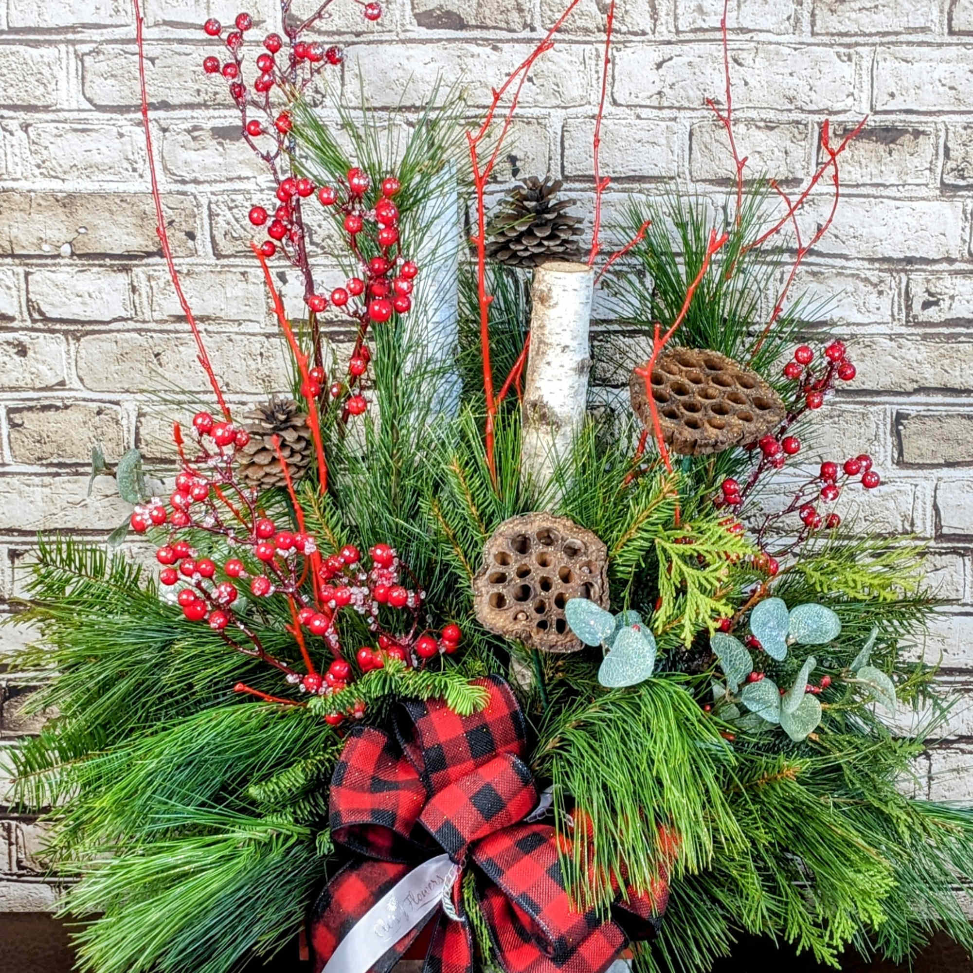 A charming evergreen porch pot with a cozy country-inspired theme, featuring a