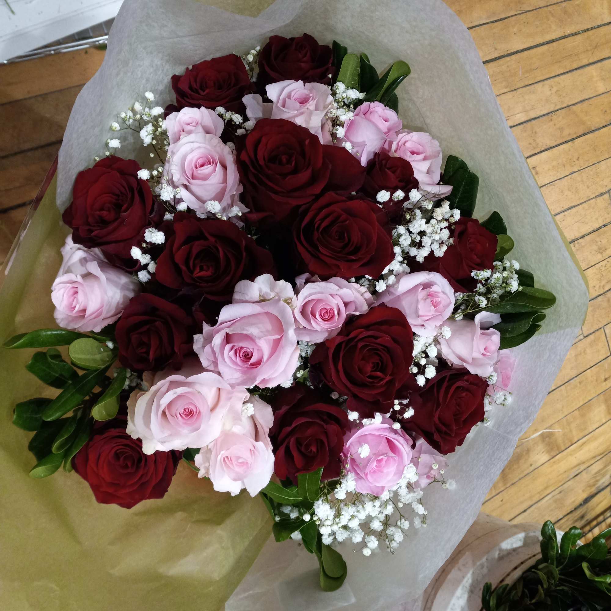 beautiful well rounded hand tied bouquet of red and pink roses with