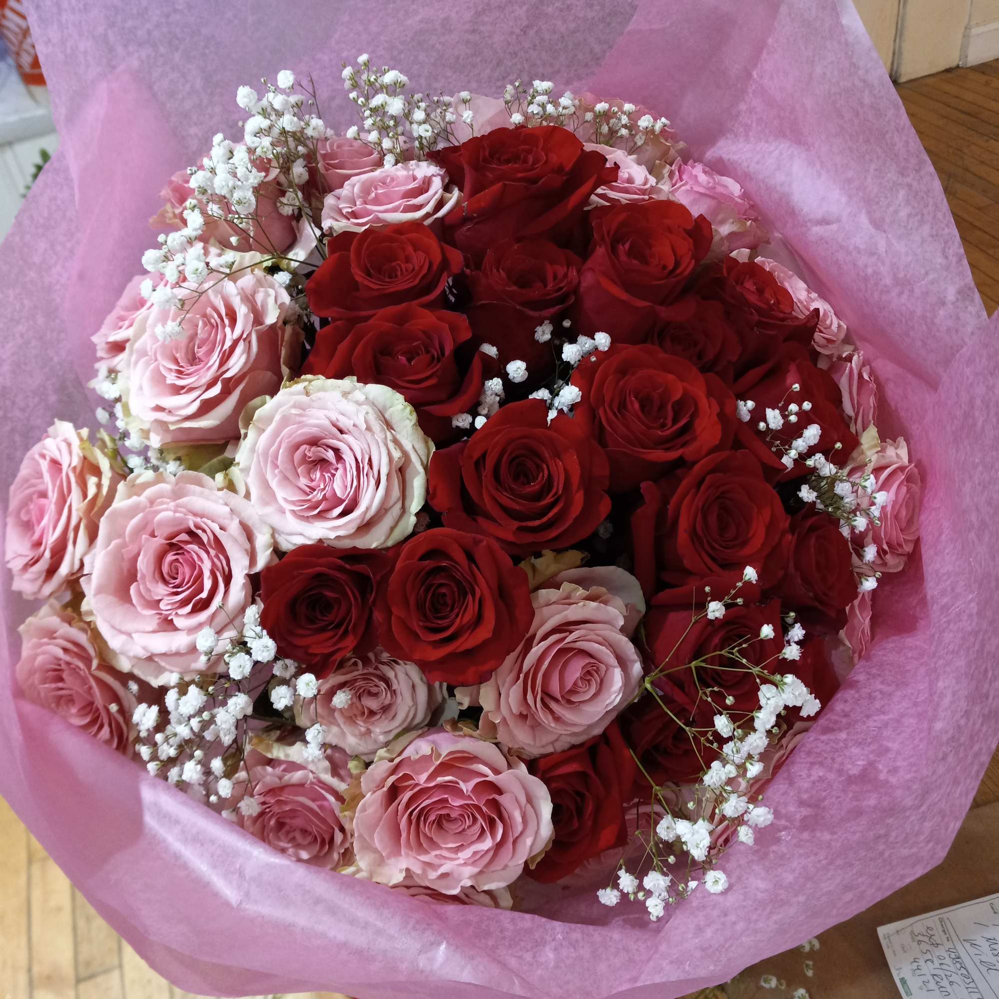 beautiful well rounded hand tied bouquet of red and pink roses with