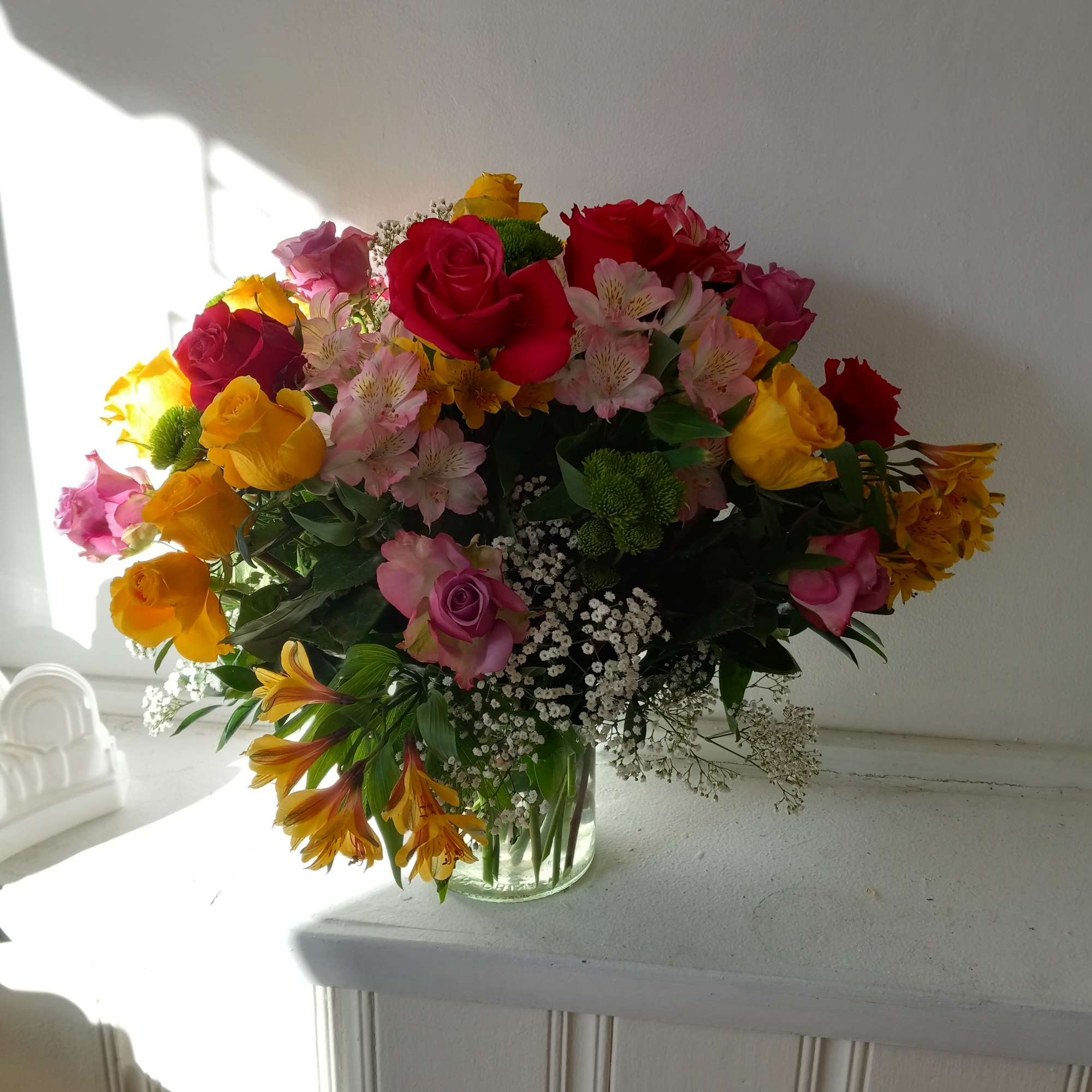 Colorful mixed colors roses in a vase with Alstroemeria, baby&#039;s breath and