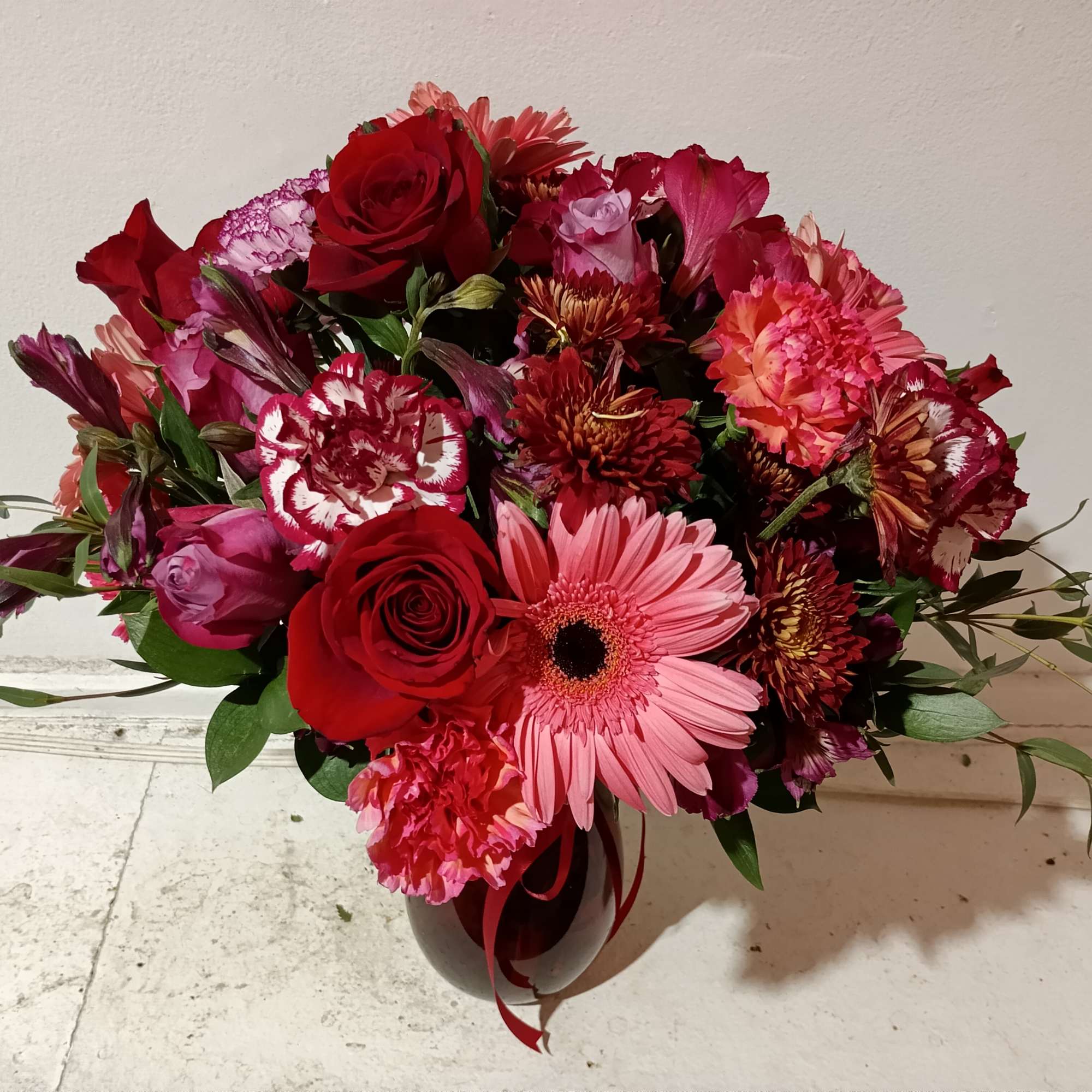 Rich and beautiful colors of burgundy alstroemeria, red roses, novelty white/burgundy and