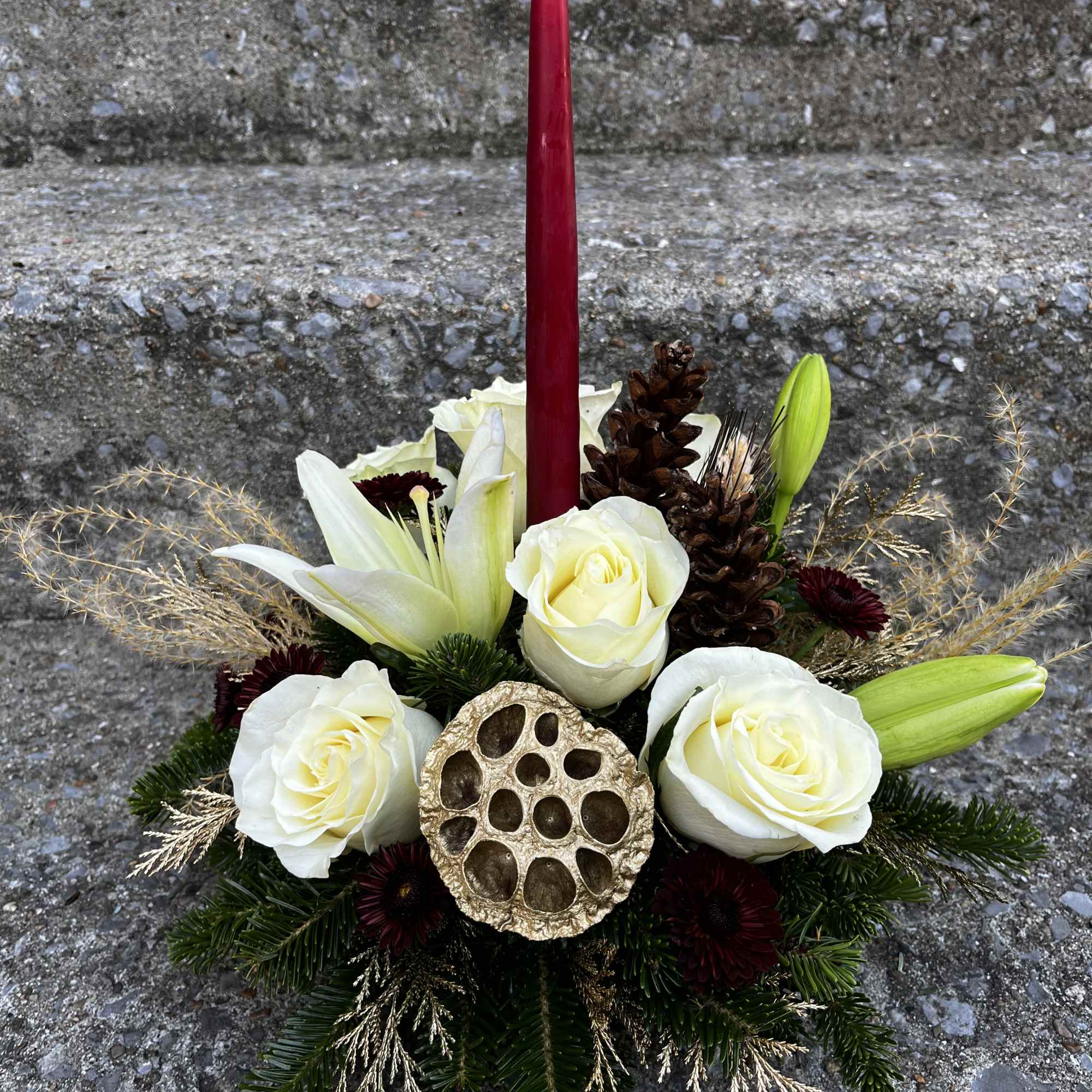 This center piece has roses, mums. Lilies, pinecones, Christmas free and golden
