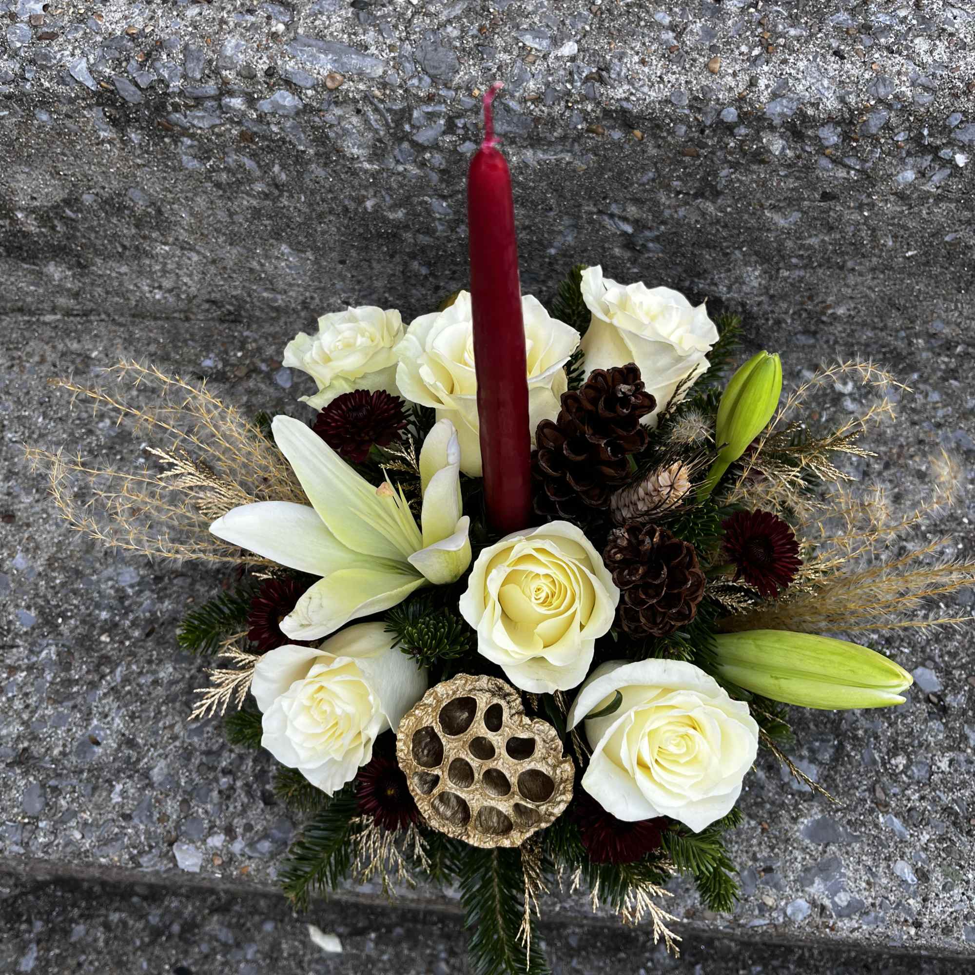 This center piece has roses, mums. Lilies, pinecones, Christmas free and golden