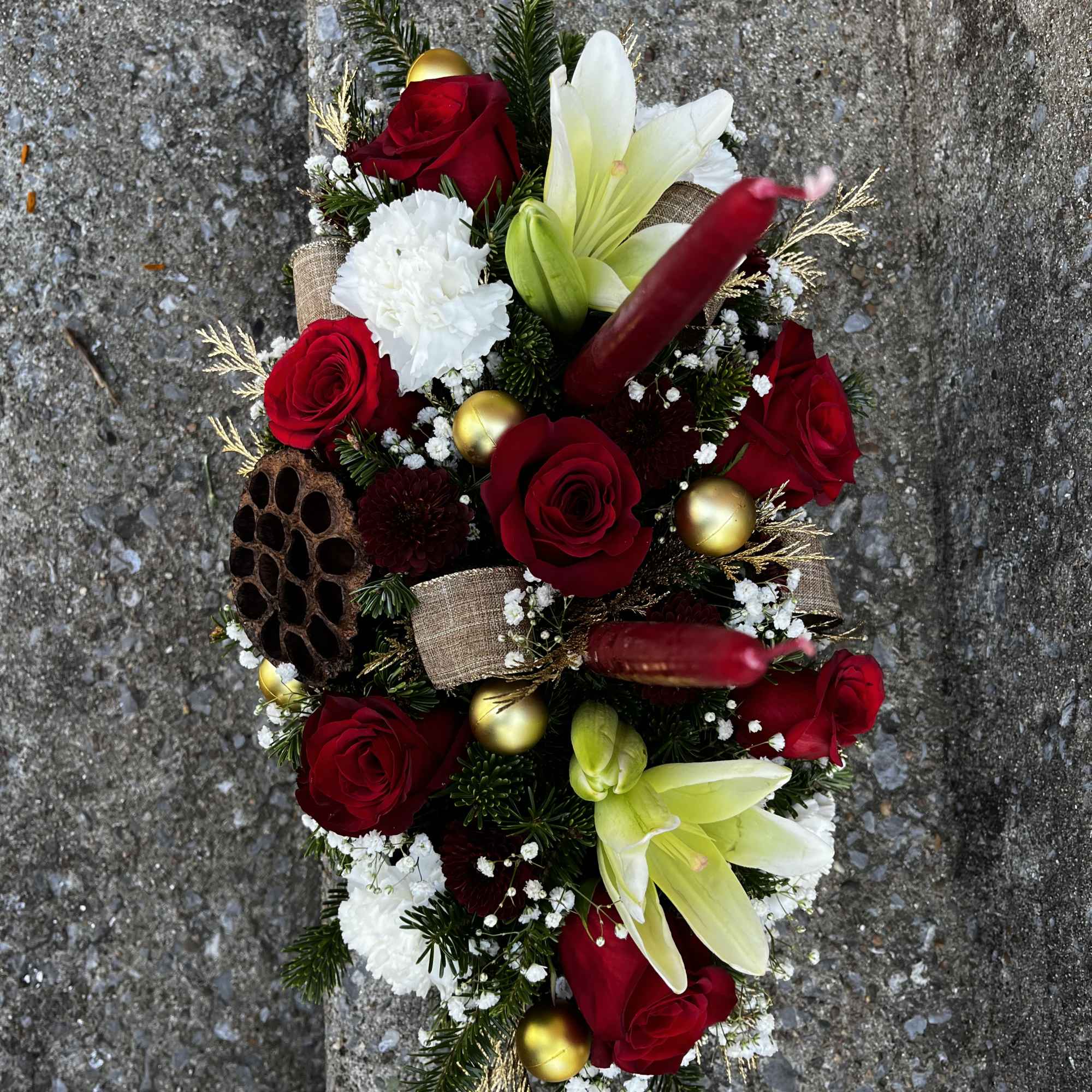 This centerpiece has roses, carnations, Lilies, babies breath, mums, Christmas ornaments, Christmas