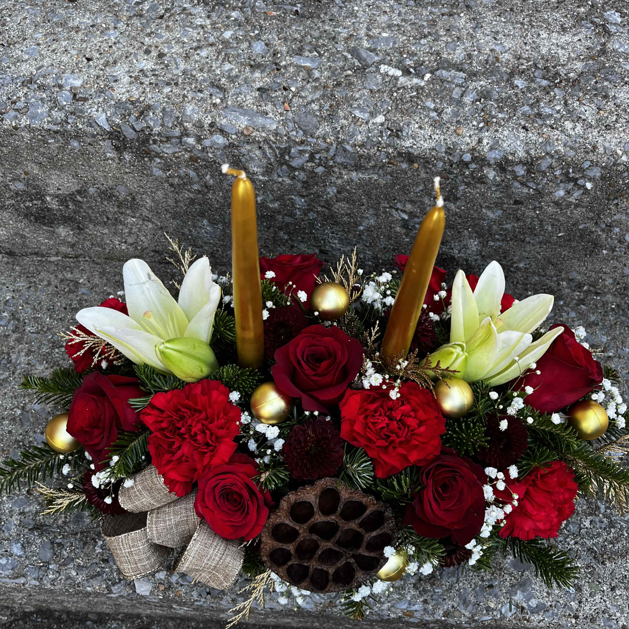 This centerpiece has roses, lilies, carnations, mums, a pinecones, ribbon Tuffs, Christmas