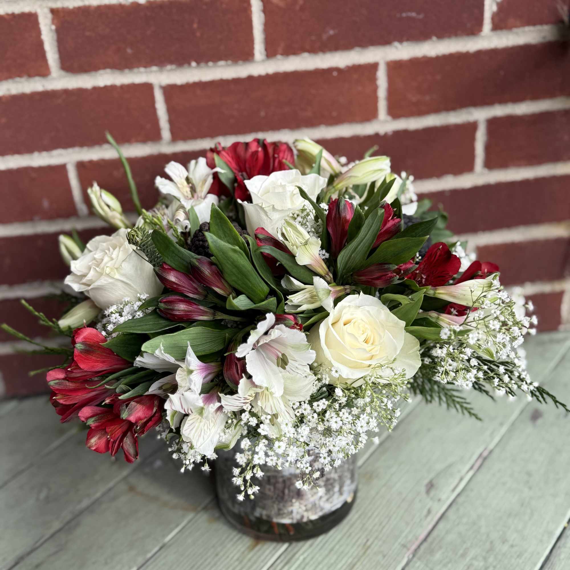 All-around arrangement with assorted Christmas greenery and pinecones.