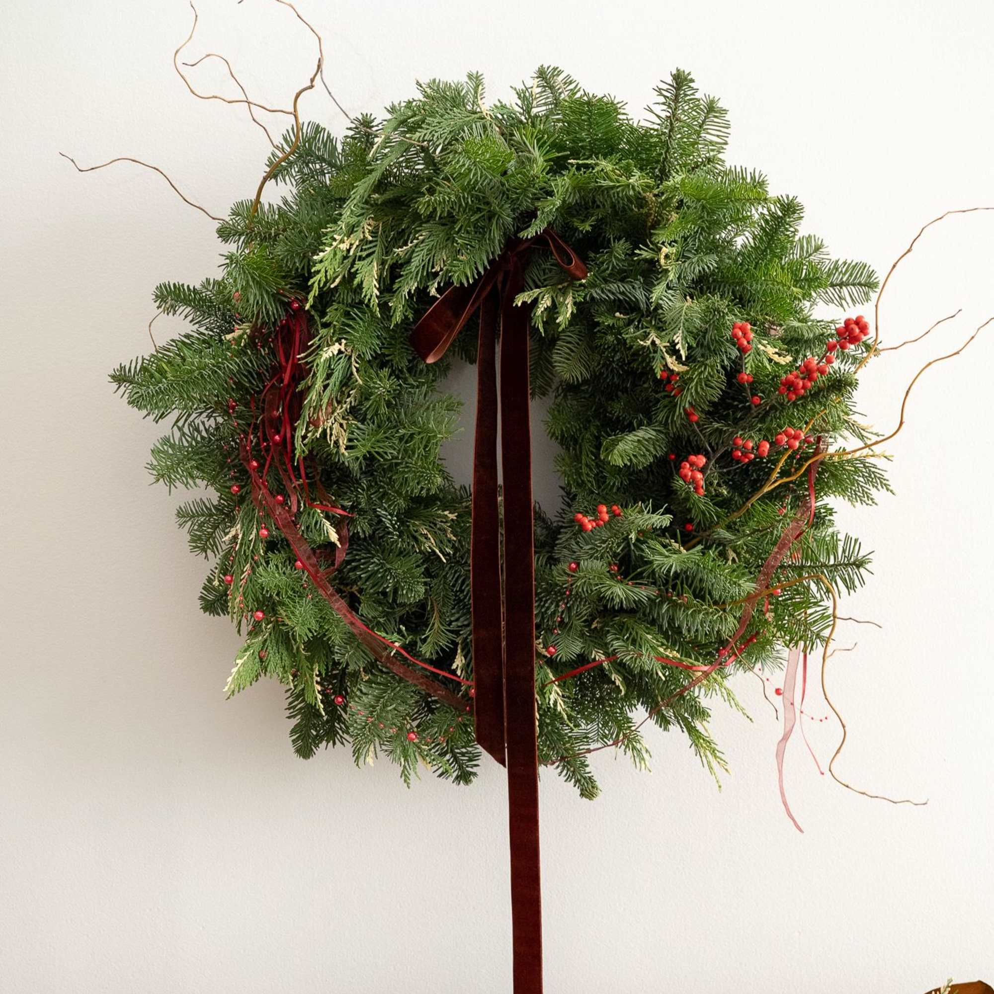 A lush and timeless Christmas wreath designed with premium, fresh winter greens
