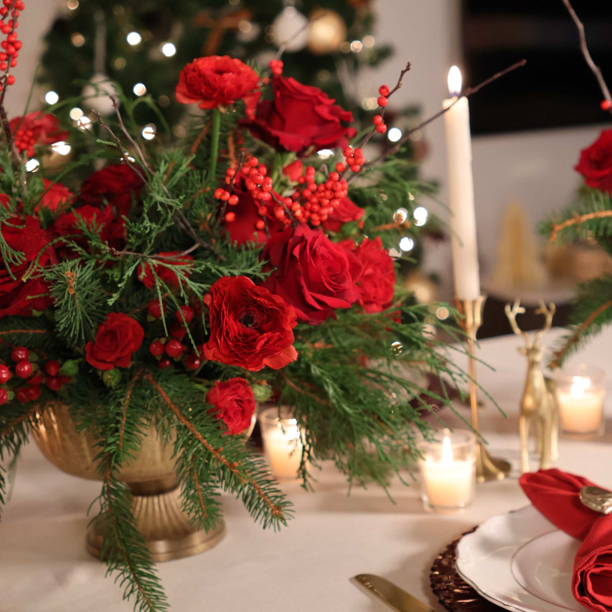 A rich, dramatic Christmas centerpiece overflowing with vibrant red blooms and lush