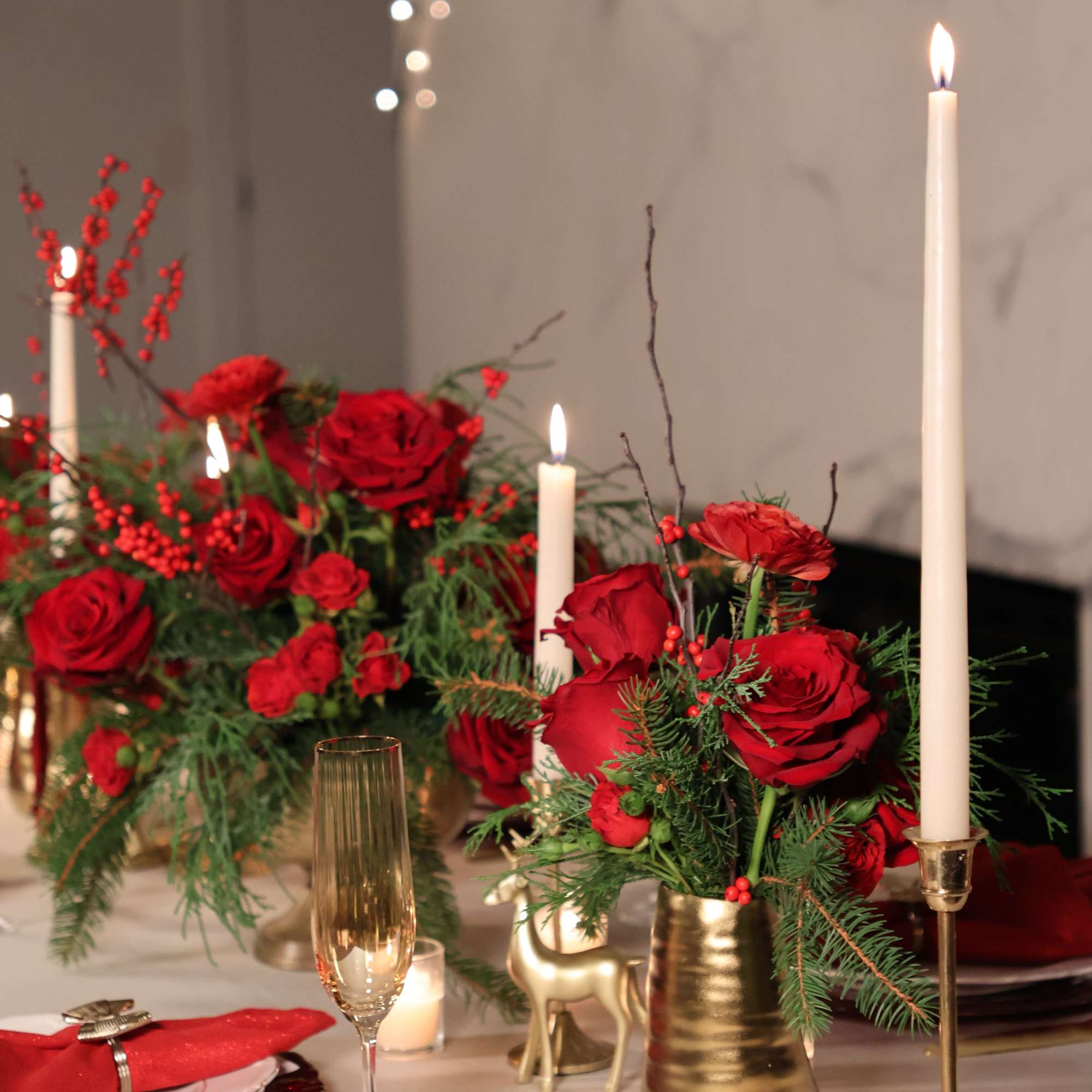 A rich, dramatic Christmas centerpiece overflowing with vibrant red blooms and lush