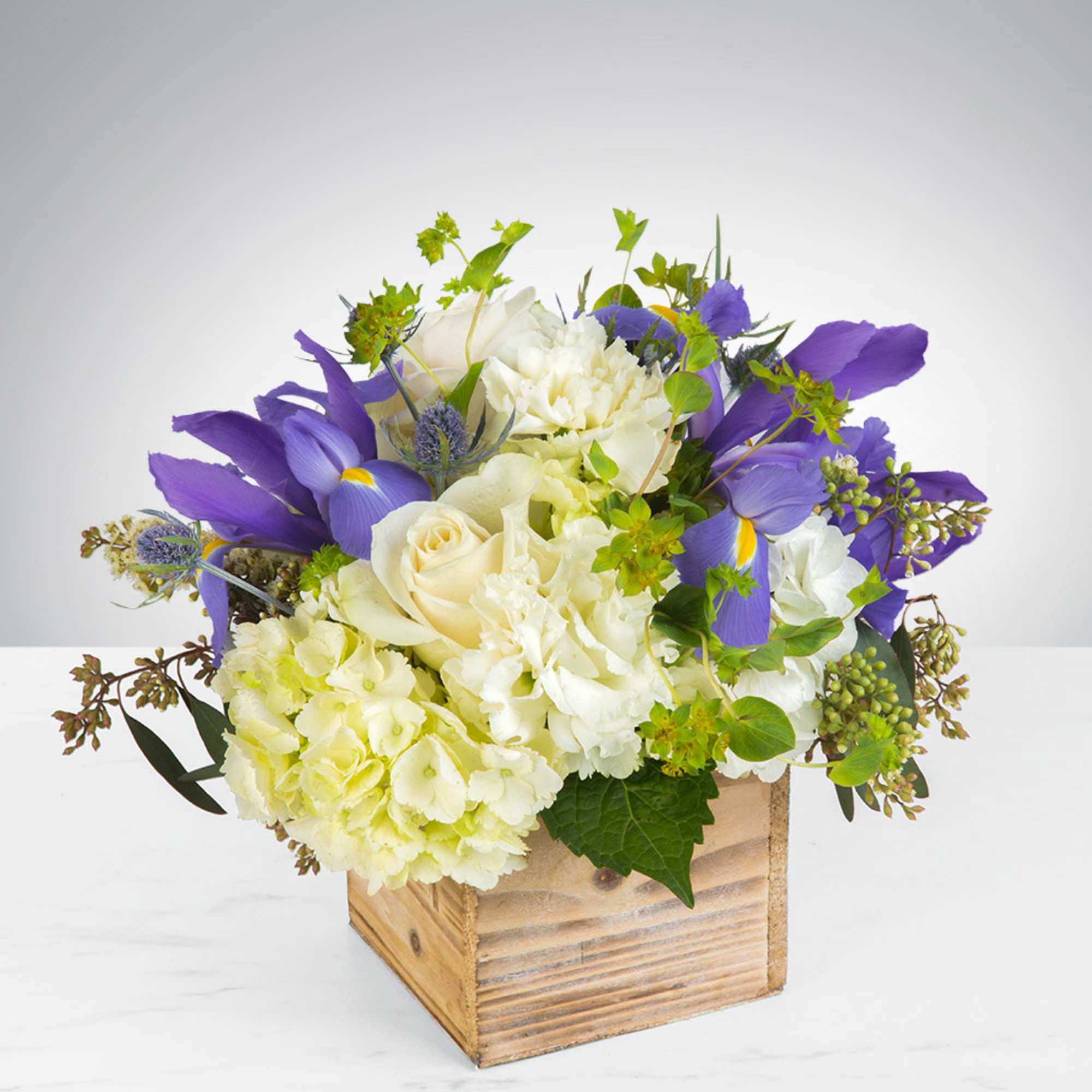 - 3 White Hydrangeas
- 6 White Roses
- 3 Blue Irises
- Wooden Vase