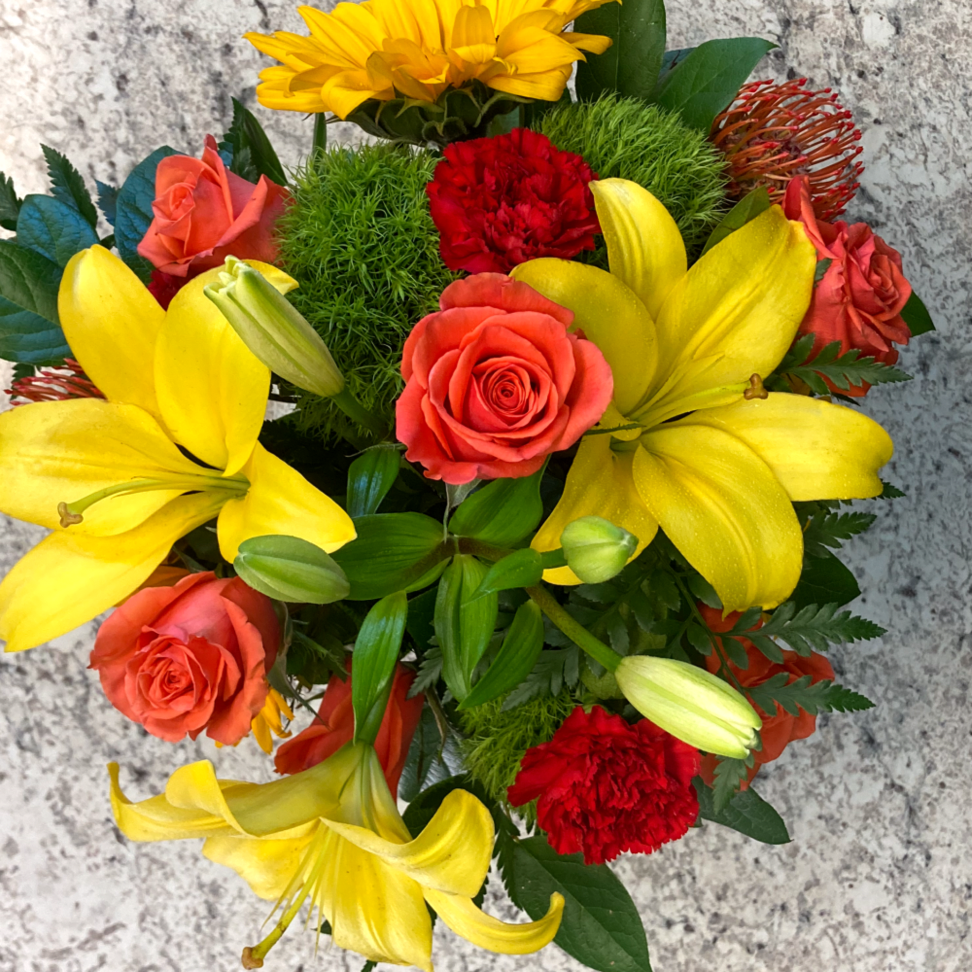 A spirited mixed arrangement showcasing vibrant shades of red, orange and yellow.