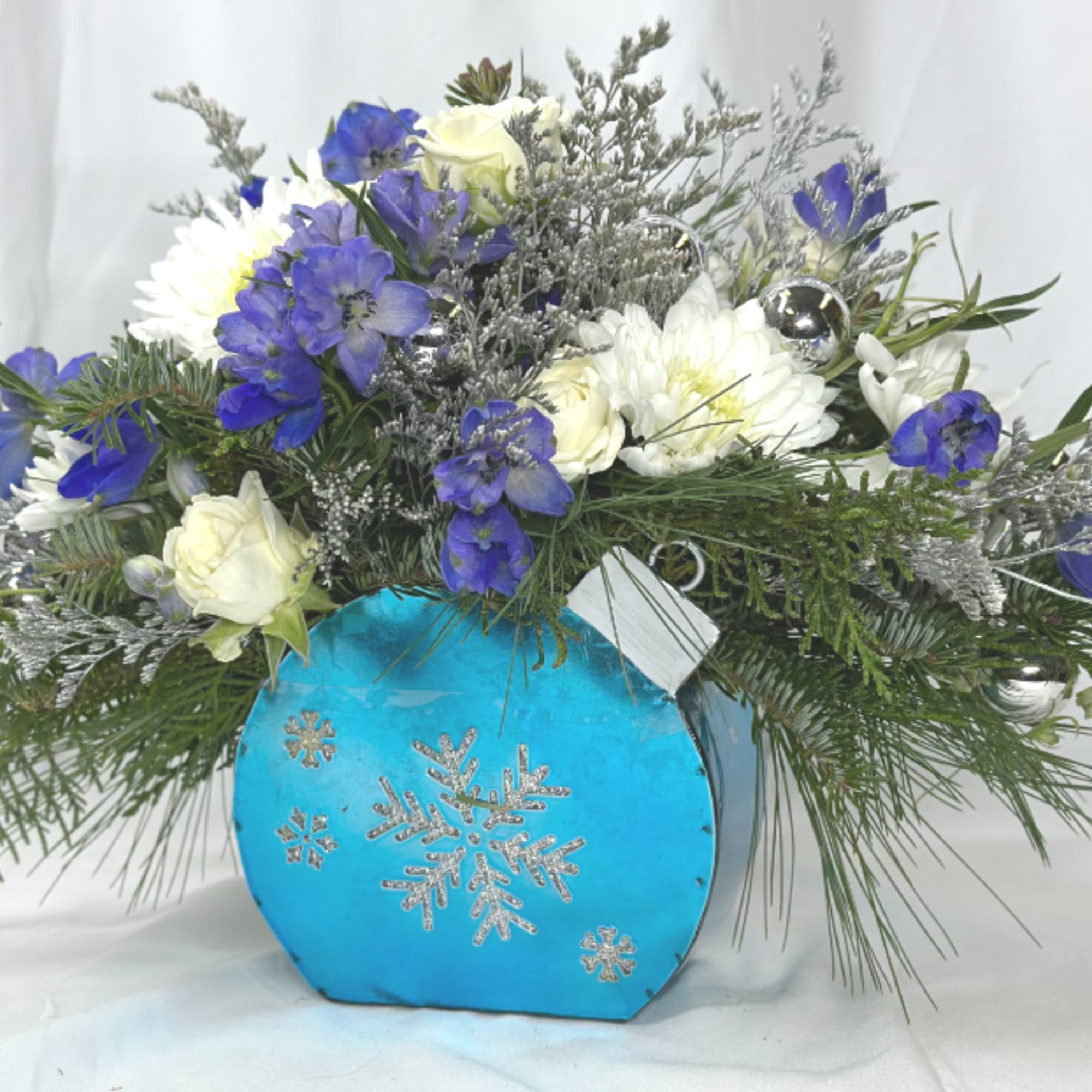 This cheerful blue and white arrangement, featuring spay roses, cushion mums, and