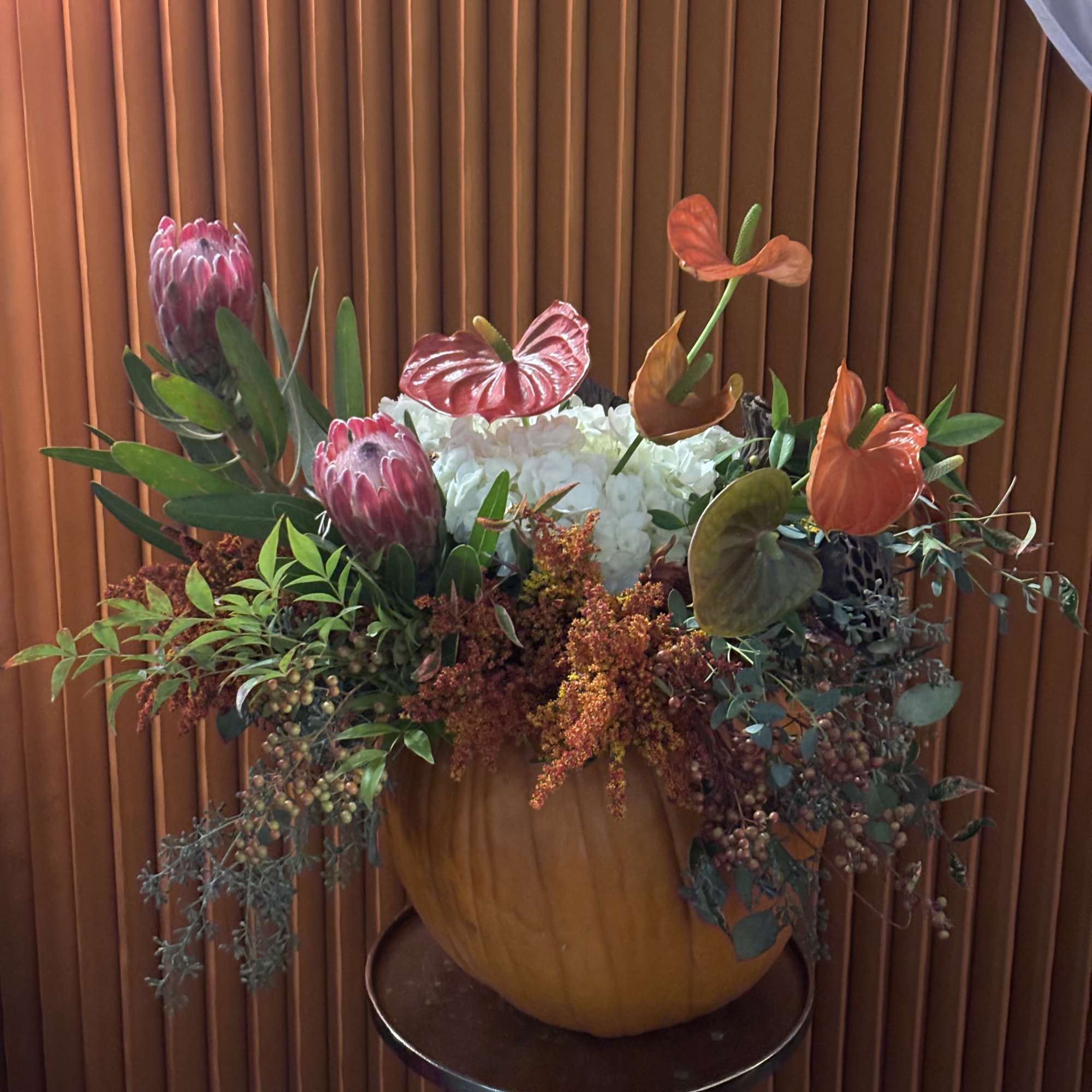 An autumnal design full of warmth with golden and orange flowers in