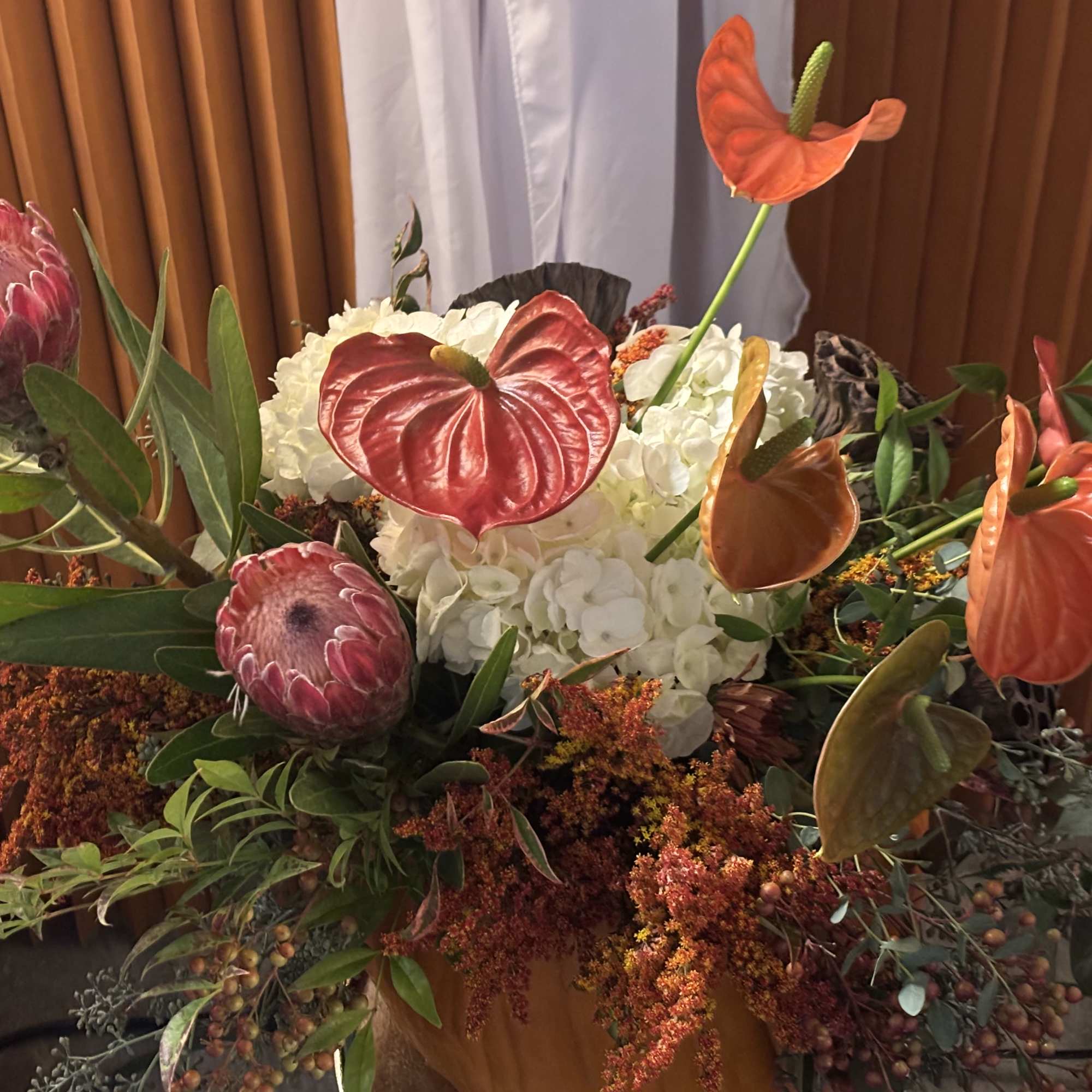 An autumnal design full of warmth with golden and orange flowers in