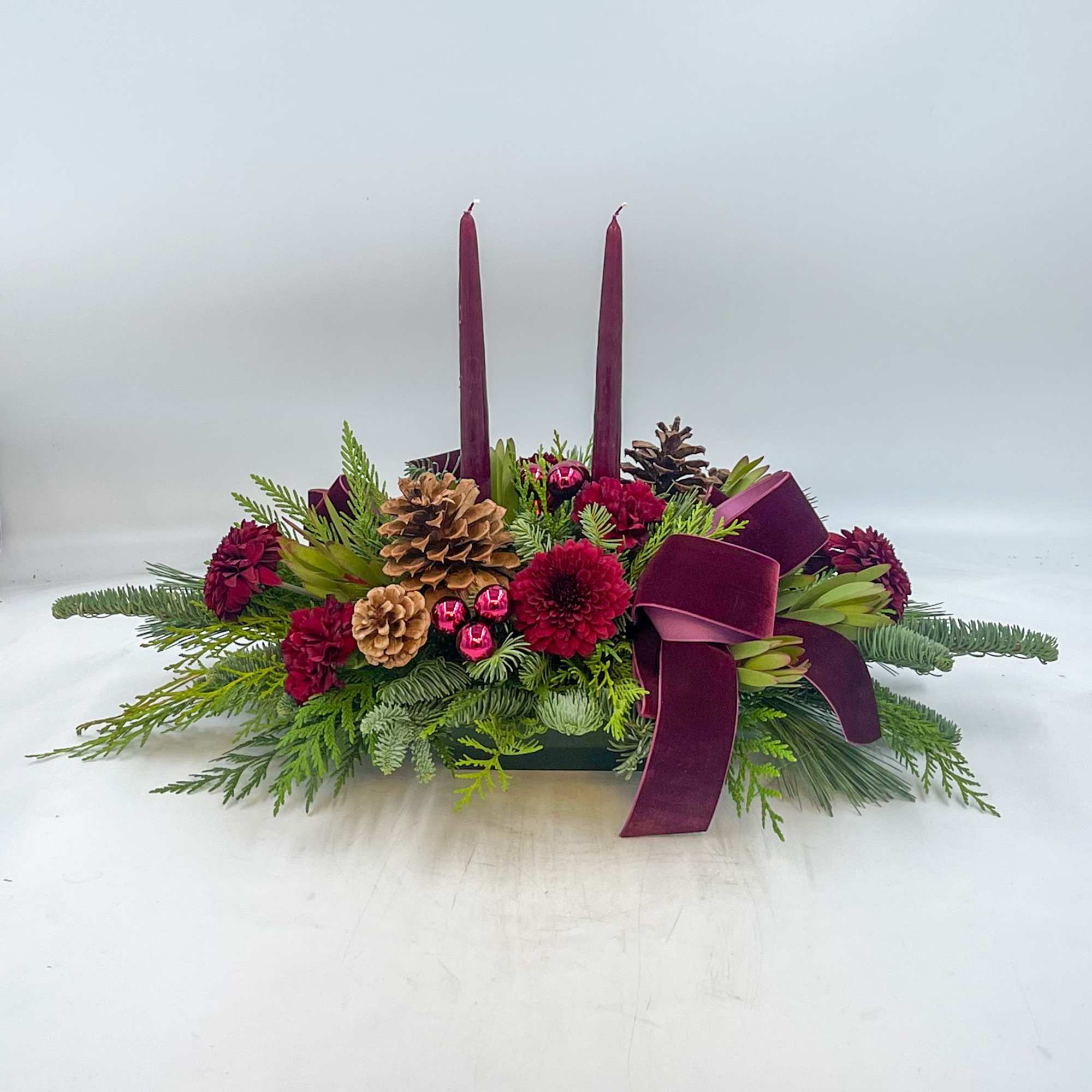 A picturesque Burgundy Christmas Centerpiece, Silent Night features Burgundy Candles, Pinecones, Burgundy