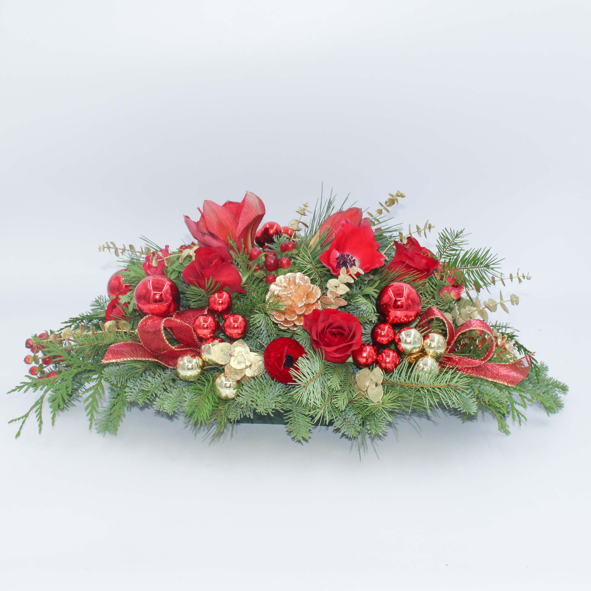 The Nutcracker is a traditional long and low centerpiece with Red Amaryllis