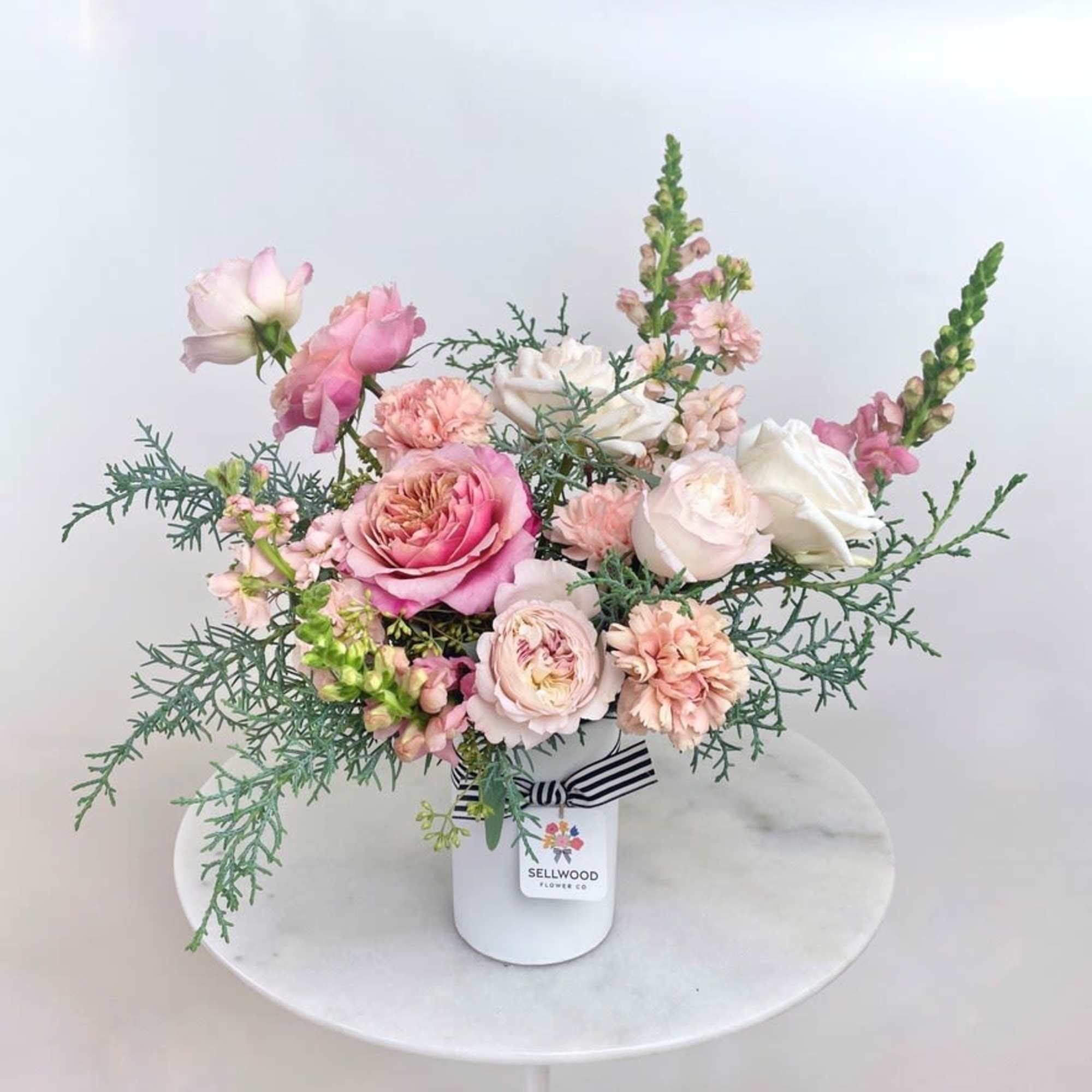This delicate and dreamy arrangement features soft blush roses, creamy white blooms